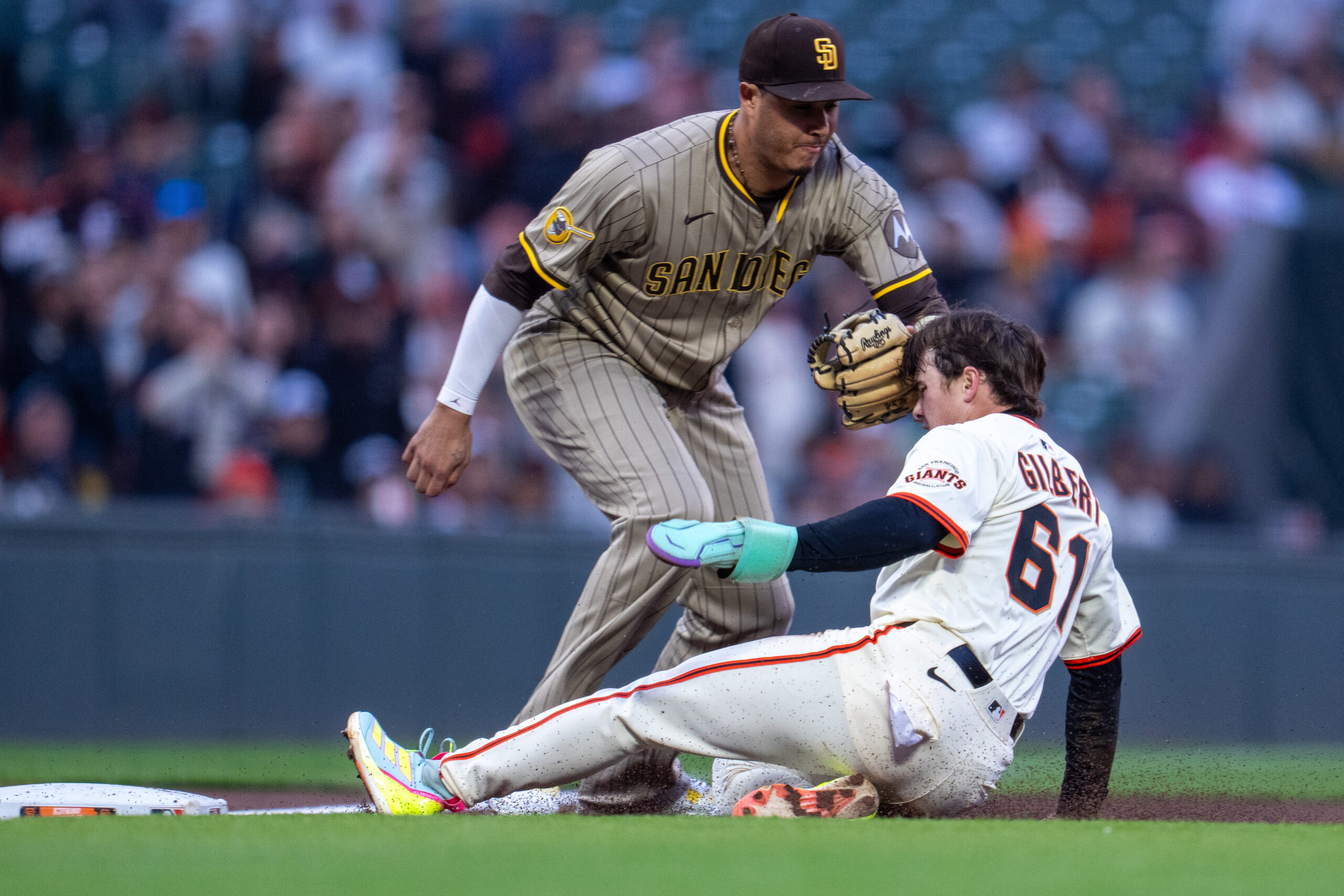 Aug 11, 2025; San Francisco, California, USA; San Diego Padres third baseman Manny Machado (13) tags out San Francisco Giants right fielder Drew Gilbert (61) attempting to steal third base during the third inning at Oracle Park. Mandatory Credit: Neville E. Guard-Imagn Images