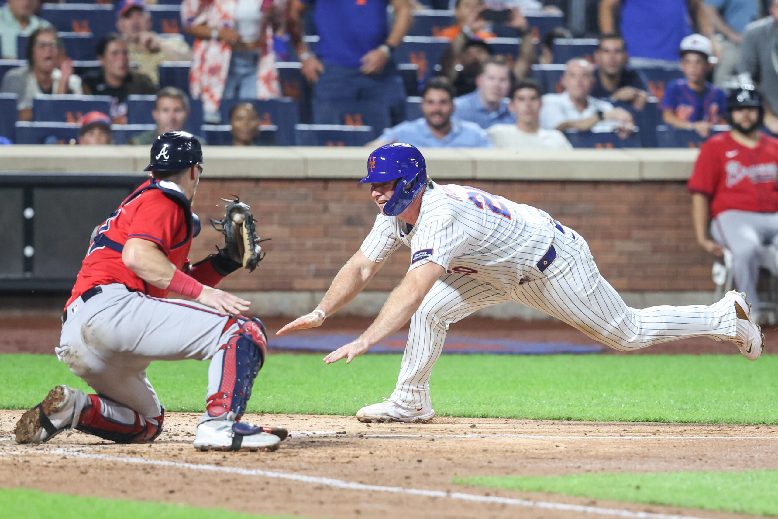 Aug 13, 2025; New York City, New York, USA;  New York Mets first baseman Pete Alonso (20) attempts to beat the tag of Atlanta Braves catcher Sean Murphy (12) in the fourth inning at Citi Field. Mandatory Credit: Wendell Cruz-Imagn Images