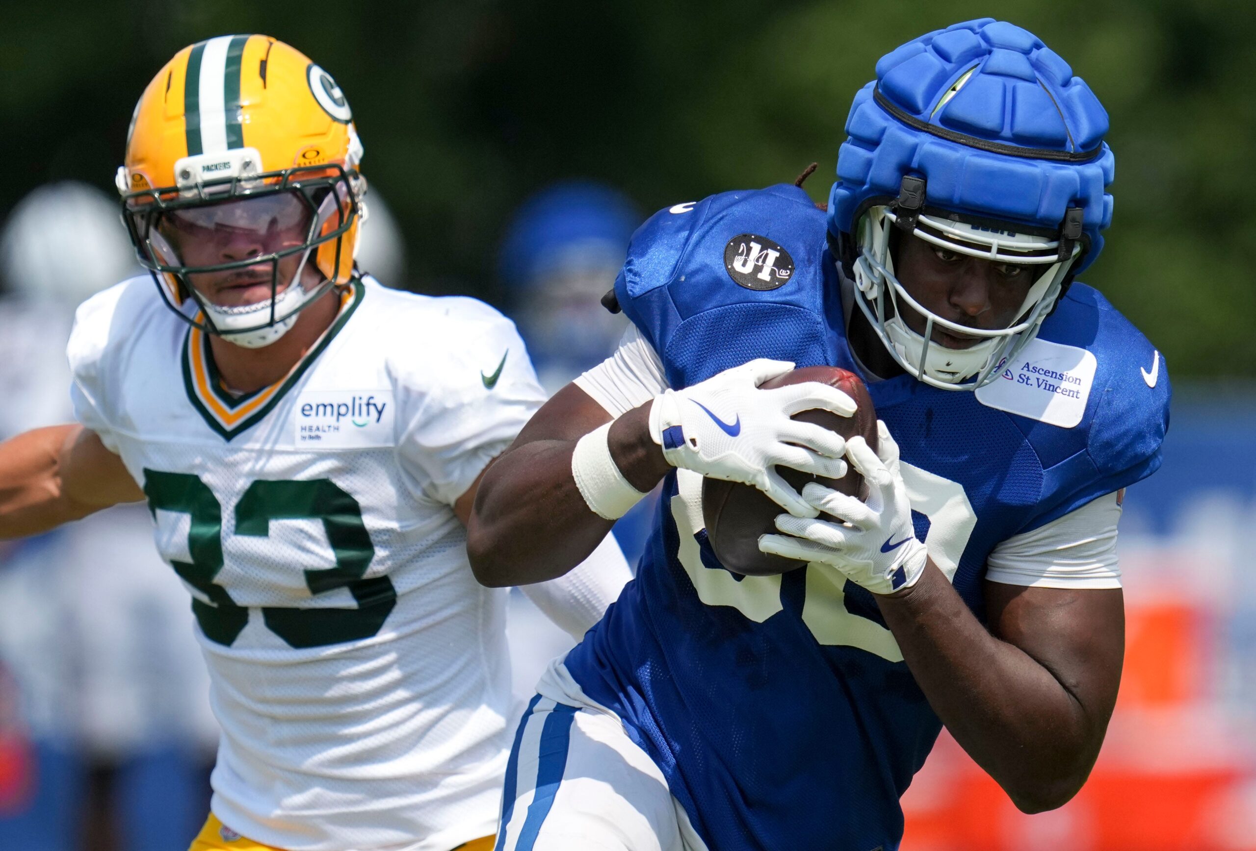 Green Bay Packers safety Evan Williams (33) attempts to take down Indianapolis Colts tight end Jelani Woods (80) on Thursday, Aug. 14, 2025, at a joint practice during Indianapolis Colts’ training camp at Grand Park in Westfield.