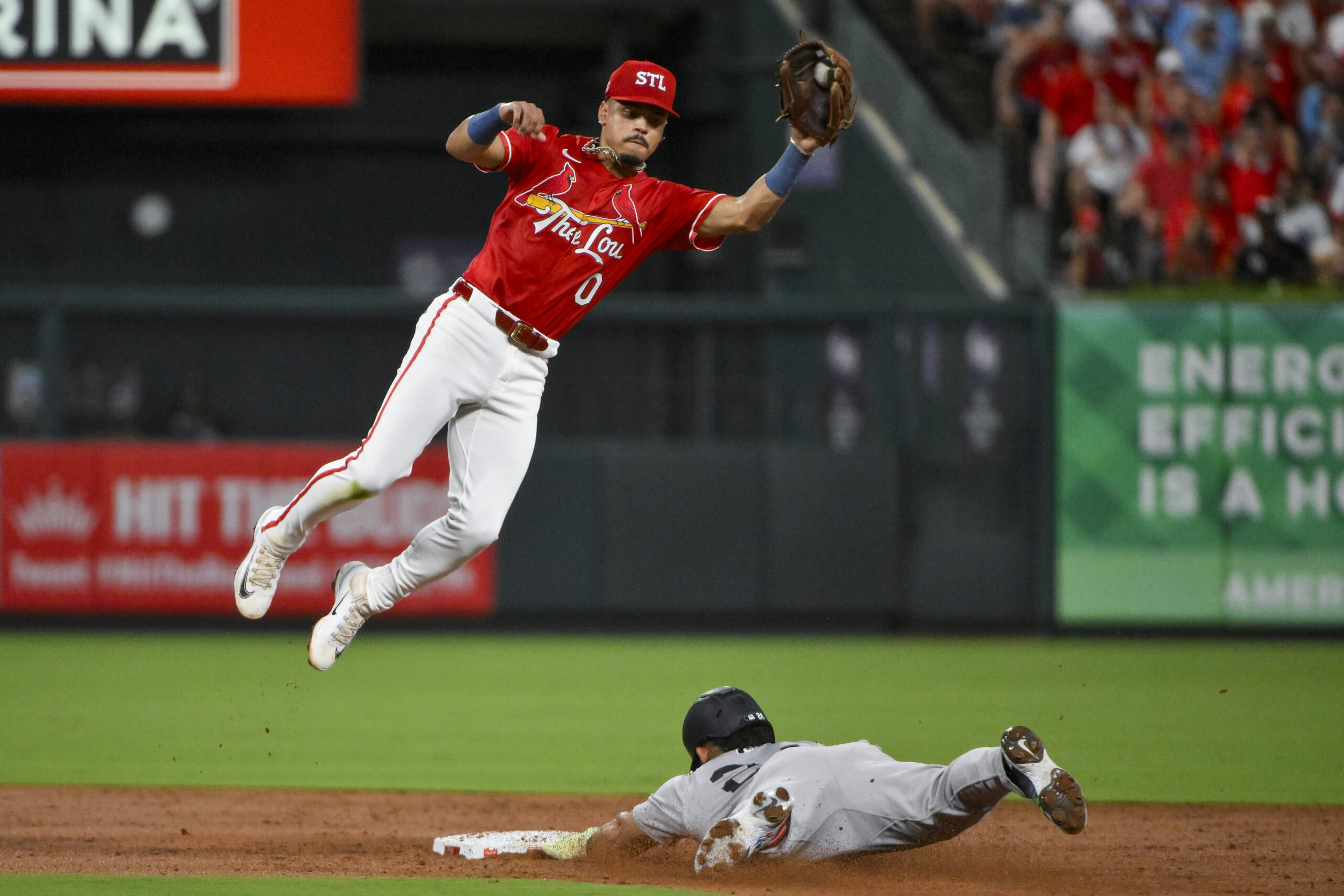 Aug 15, 2025; St. Louis, Missouri, USA;  St. Louis Cardinals shortstop Masyn Winn (0) leaps to field the throw and tags out New York Yankees left fielder Jasson Dominguez (24) during the third inning at Busch Stadium. Mandatory Credit: Jeff Curry-Imagn Images