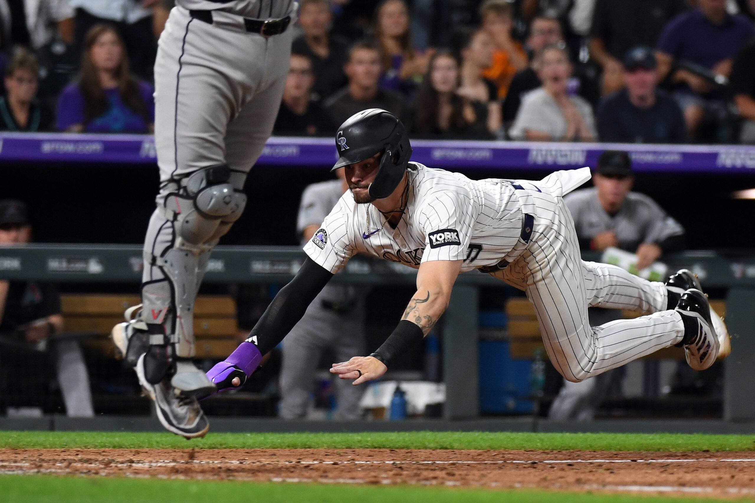 Aug 16, 2025; Denver, Colorado, USA; Colorado Rockies outfielder Brenton Doyle (9) slides safely into home ahead of the tag by Arizona Diamondbacks catcher Adrian Del Castillo (25) during the eighth inning at Coors Field. Mandatory Credit: Christopher Hanewinckel-Imagn Images