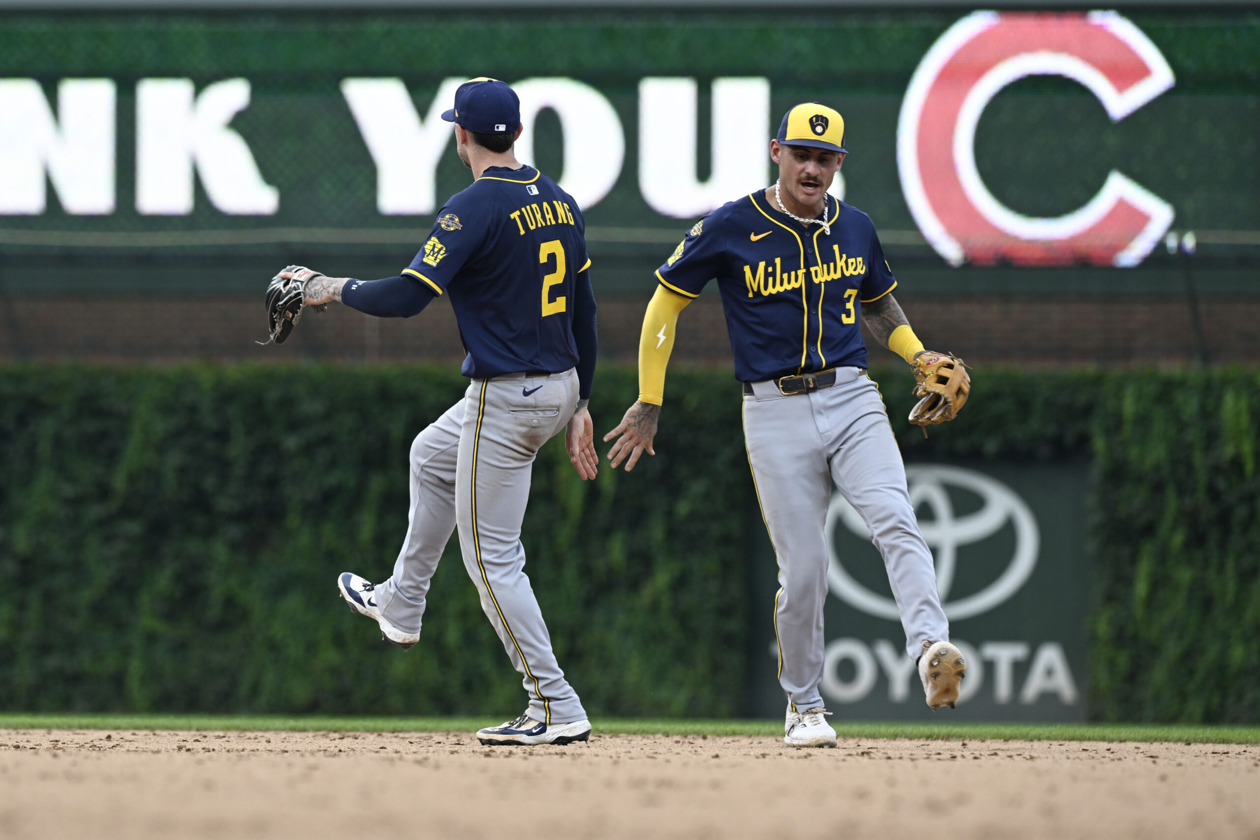 Aug 18, 2025; Chicago, Illinois, USA; Milwaukee Brewers second baseman Brice Turang (2) and shortstop Joey Ortiz (3) celebrate after the game against the Chicago Cubs at Wrigley Field. Mandatory Credit: Matt Marton-Imagn Images