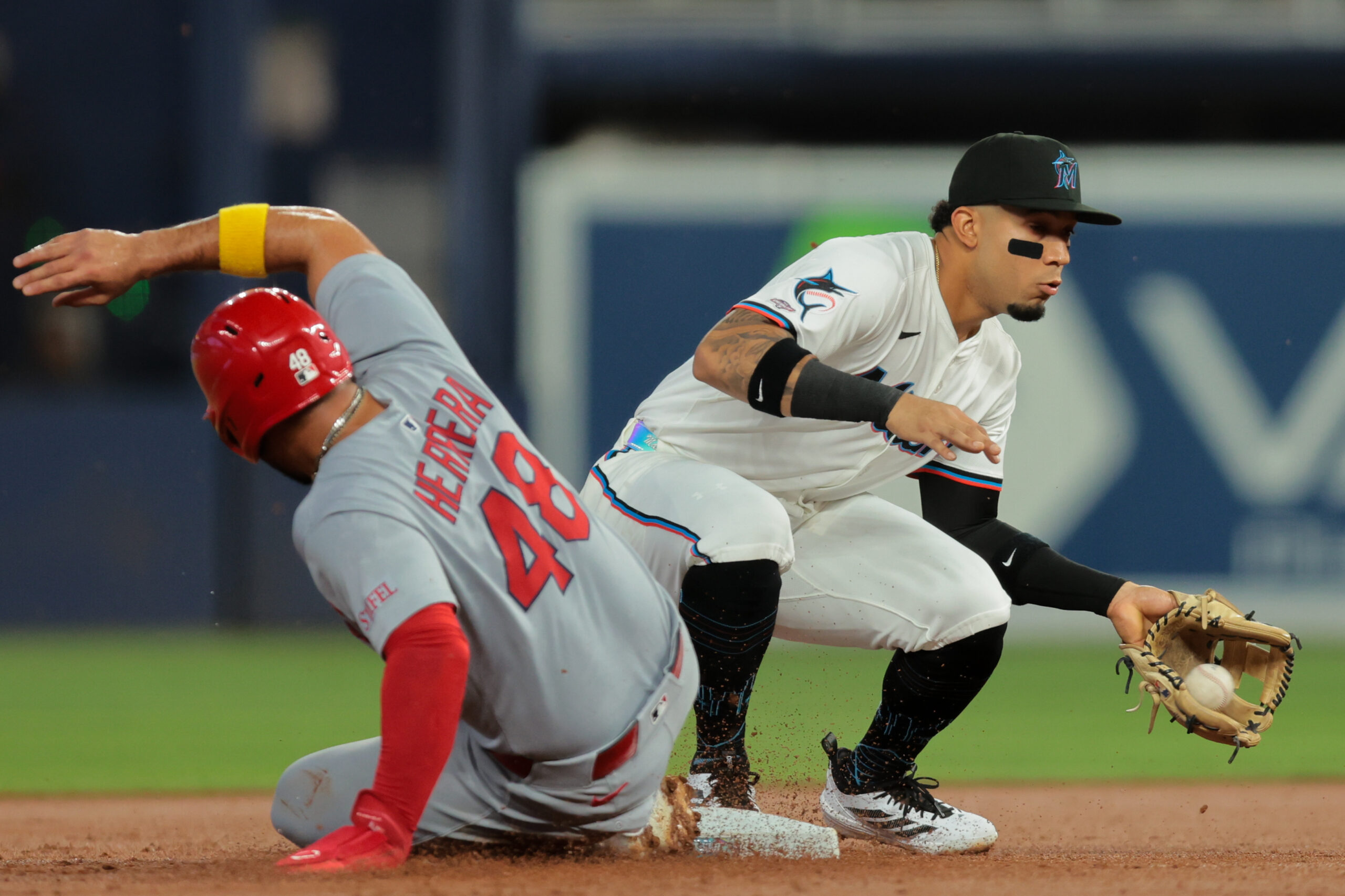 Aug 18, 2025; Miami, Florida, USA; St. Louis Cardinals designated hitter Ivan Herrera (48) slides back into second base against Miami Marlins second baseman Maximo Acosta (24) during the first inning at loanDepot Park. Mandatory Credit: Sam Navarro-Imagn Images