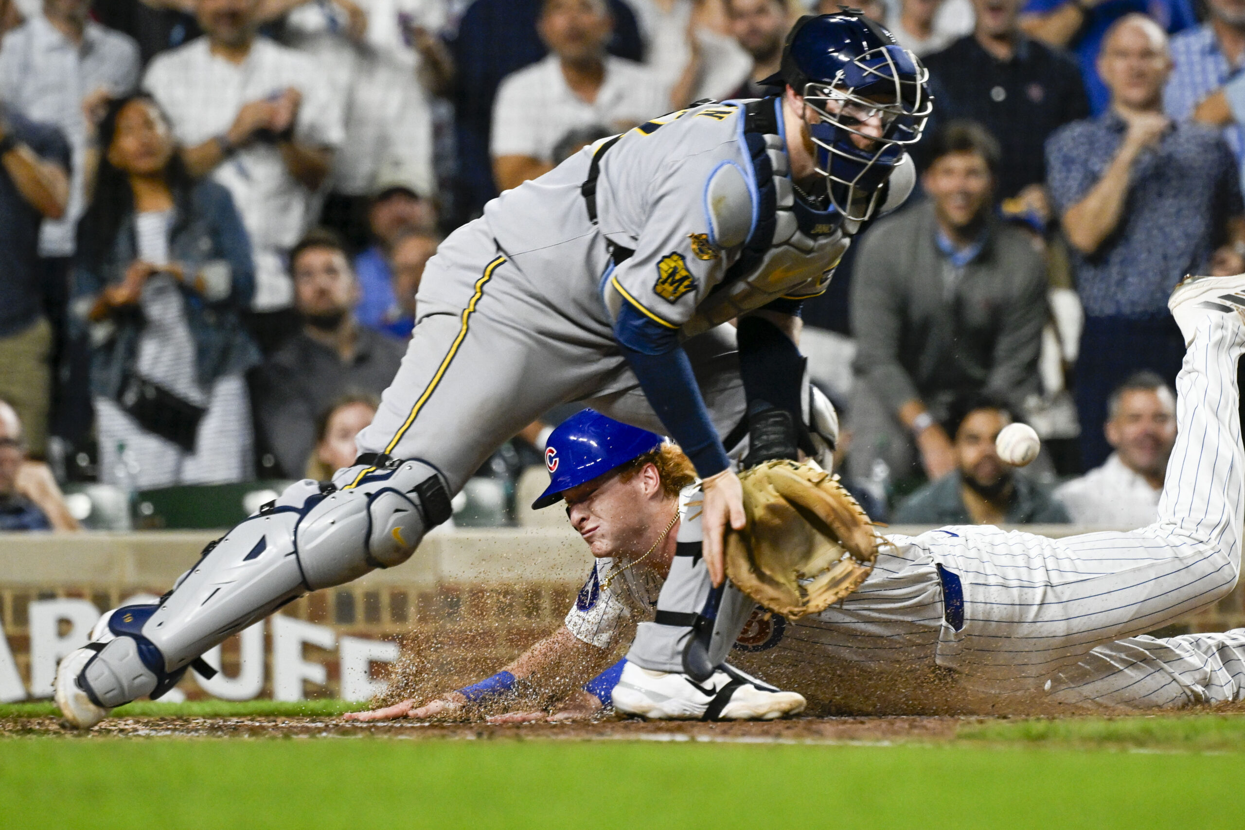 Aug 19, 2025; Chicago, Illinois, USA; Chicago Cubs outfielder Owen Caissie (19) scores past Milwaukee Brewers catcher Danny Jansen (33) during the second inning at Wrigley Field. Mandatory Credit: Matt Marton-Imagn Images