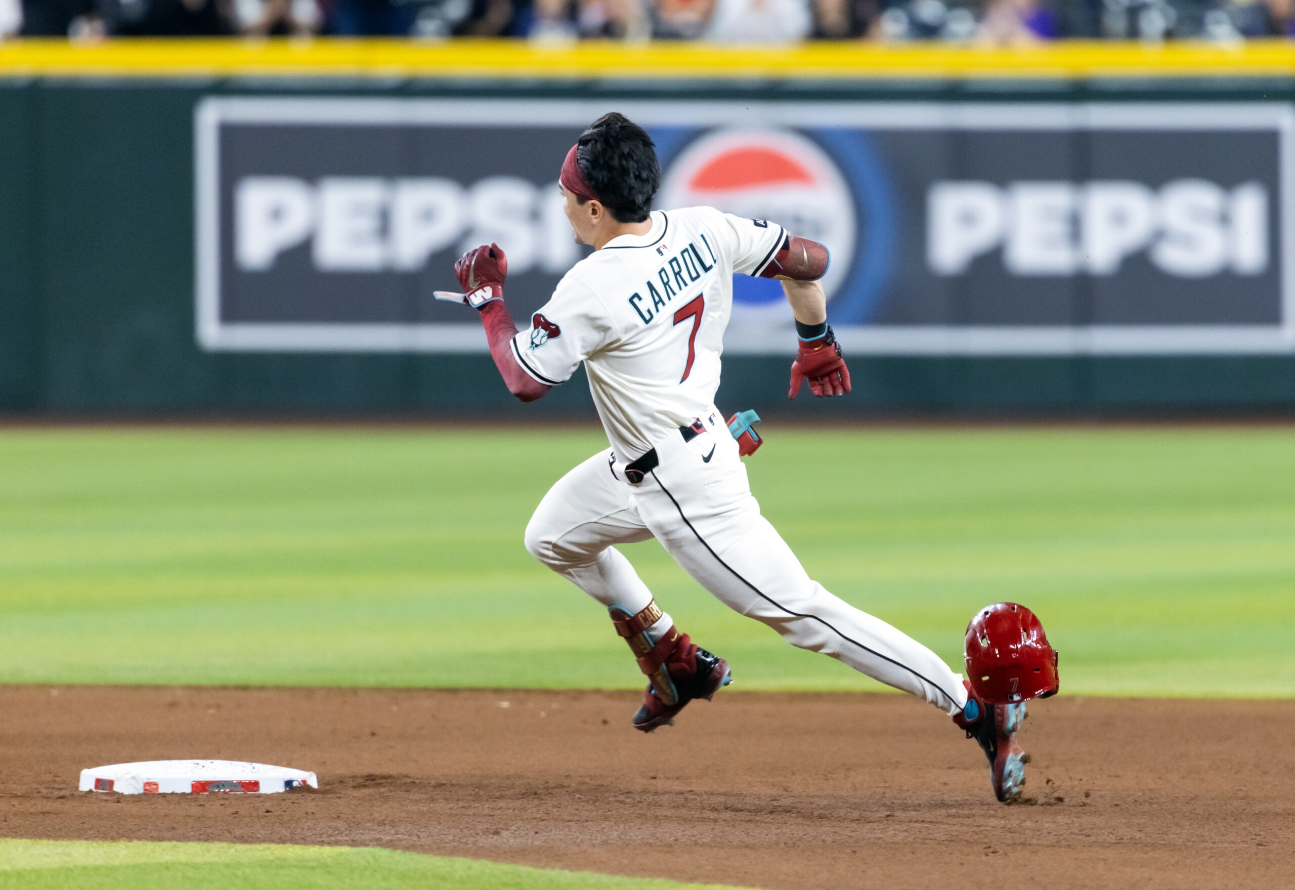 Aug 19, 2025; Phoenix, Arizona, USA; Arizona Diamondbacks outfielder Corbin Carroll loses his helmet as he runs the bases after hitting a triple in the fourth inning against the Cleveland Guardians at Chase Field. Mandatory Credit: Mark J. Rebilas-Imagn Images