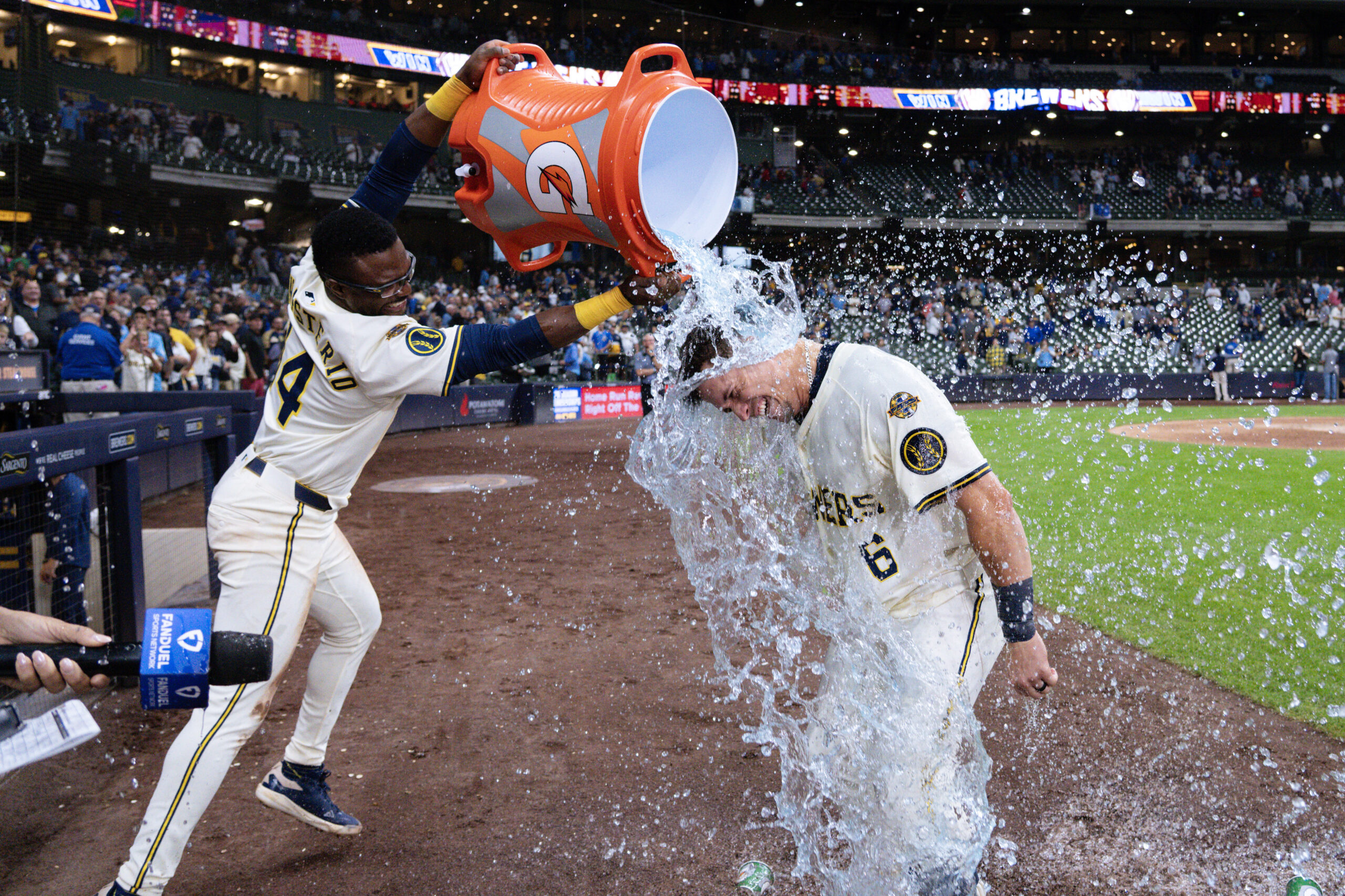 Aug 26, 2025; Milwaukee, Wisconsin, USA;  Milwaukee Brewers left fielder Isaac Collins (6) is dunked with Gatorade by  Andruw Monasterio (14) after driving in the winning run during the ninth inning against the Arizona Diamondbacks at American Family Field. Mandatory Credit: Jeff Hanisch-Imagn Images