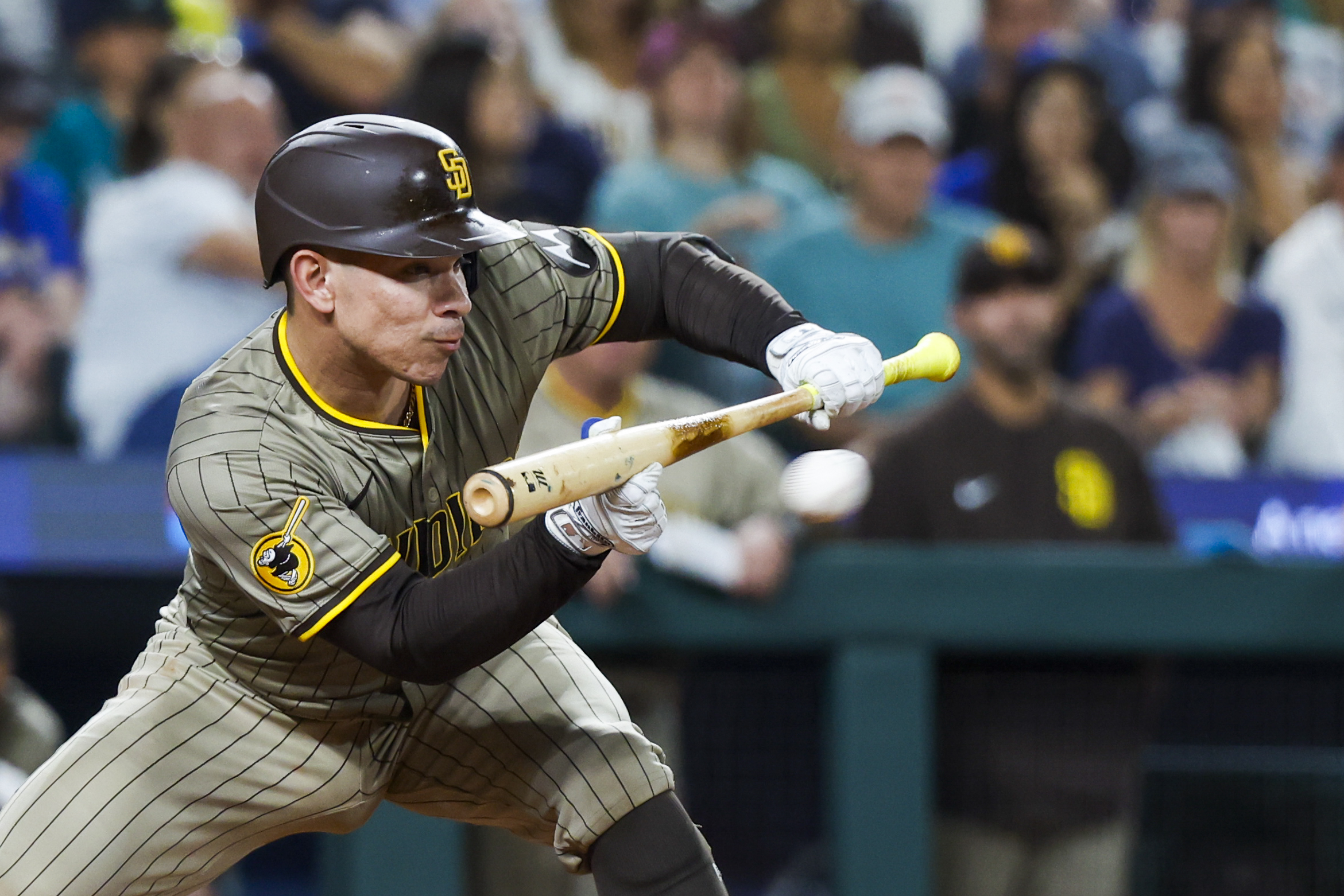 Aug 26, 2025; Seattle, Washington, USA; San Diego Padres catcher Freddy Fermin (54) hits an RBI-sacrifice bunt against the Seattle Mariners during the sixth inning at T-Mobile Park. Mandatory Credit: Joe Nicholson-Imagn Images