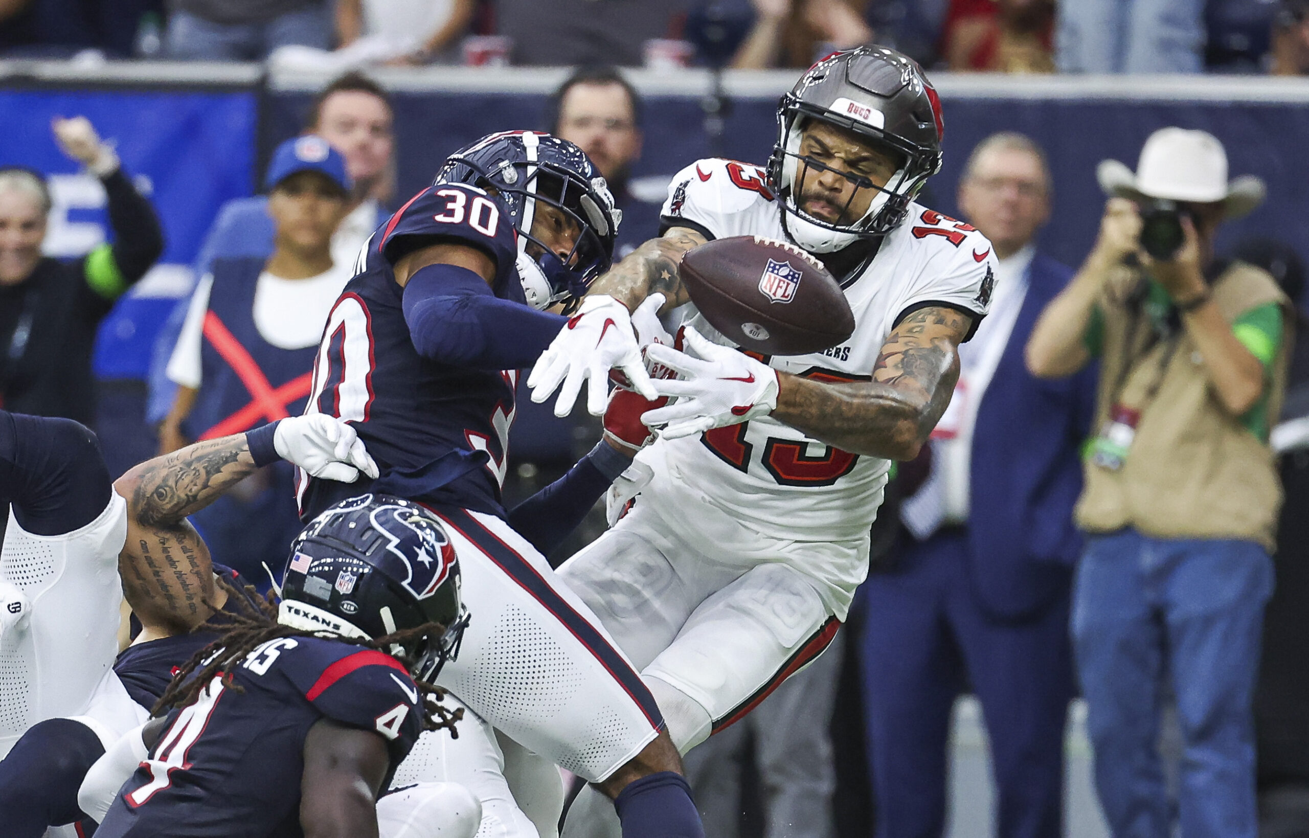 Nov 5, 2023; Houston, Texas, USA; Houston Texans safety DeAndre Houston-Carson (30) and Tampa Bay Buccaneers wide receiver Mike Evans (13) attempt to recover a fumble during the fourth quarter at NRG Stadium. Mandatory Credit: Troy Taormina-Imagn Images