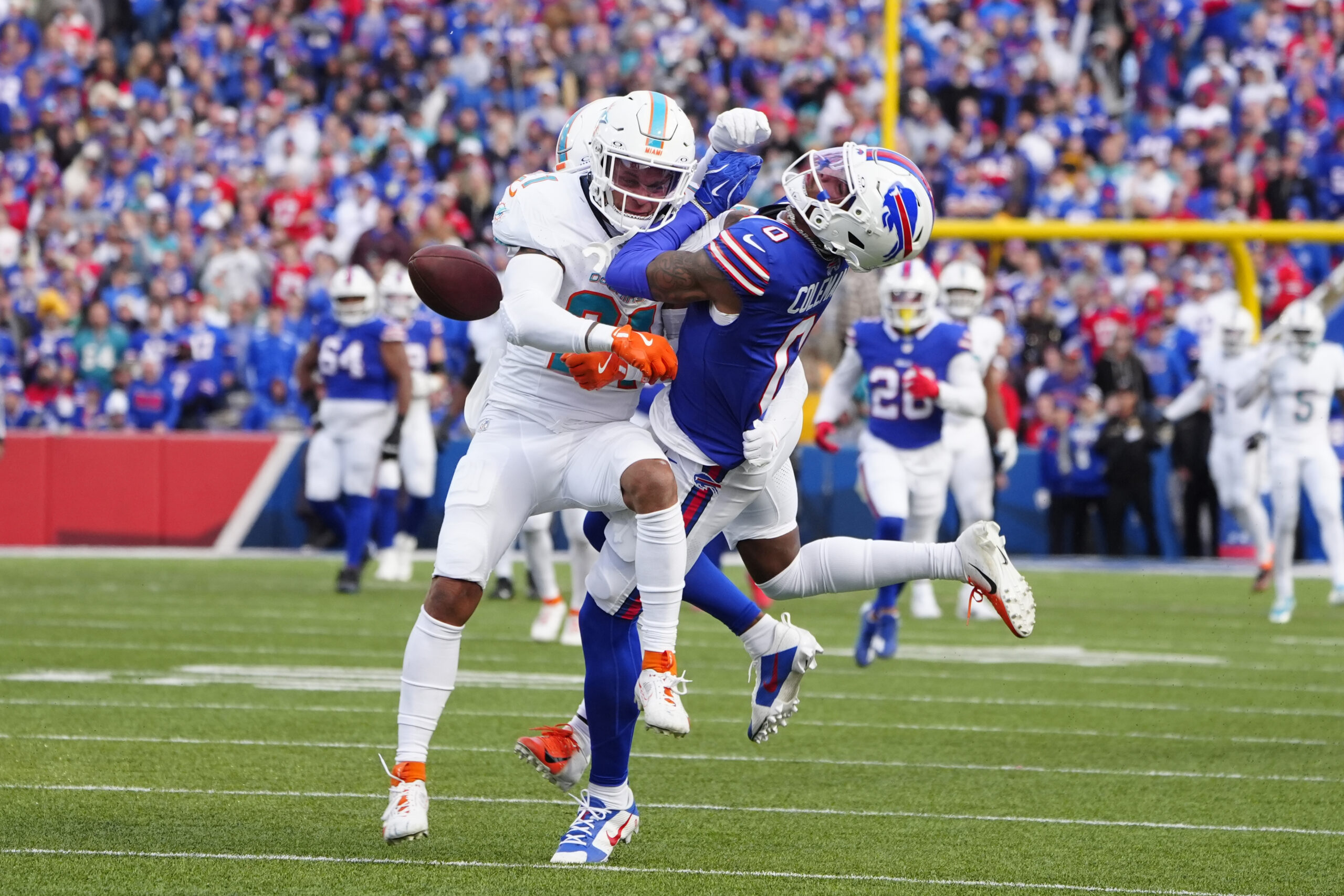 Nov 3, 2024; Orchard Park, New York, USA; Miami Dolphins safety Jordan Poyer (21) separates Buffalo Bills wide receiver Keon Coleman (0) from the ball to break up a pass during the second half at Highmark Stadium. Mandatory Credit: Gregory Fisher-Imagn Images