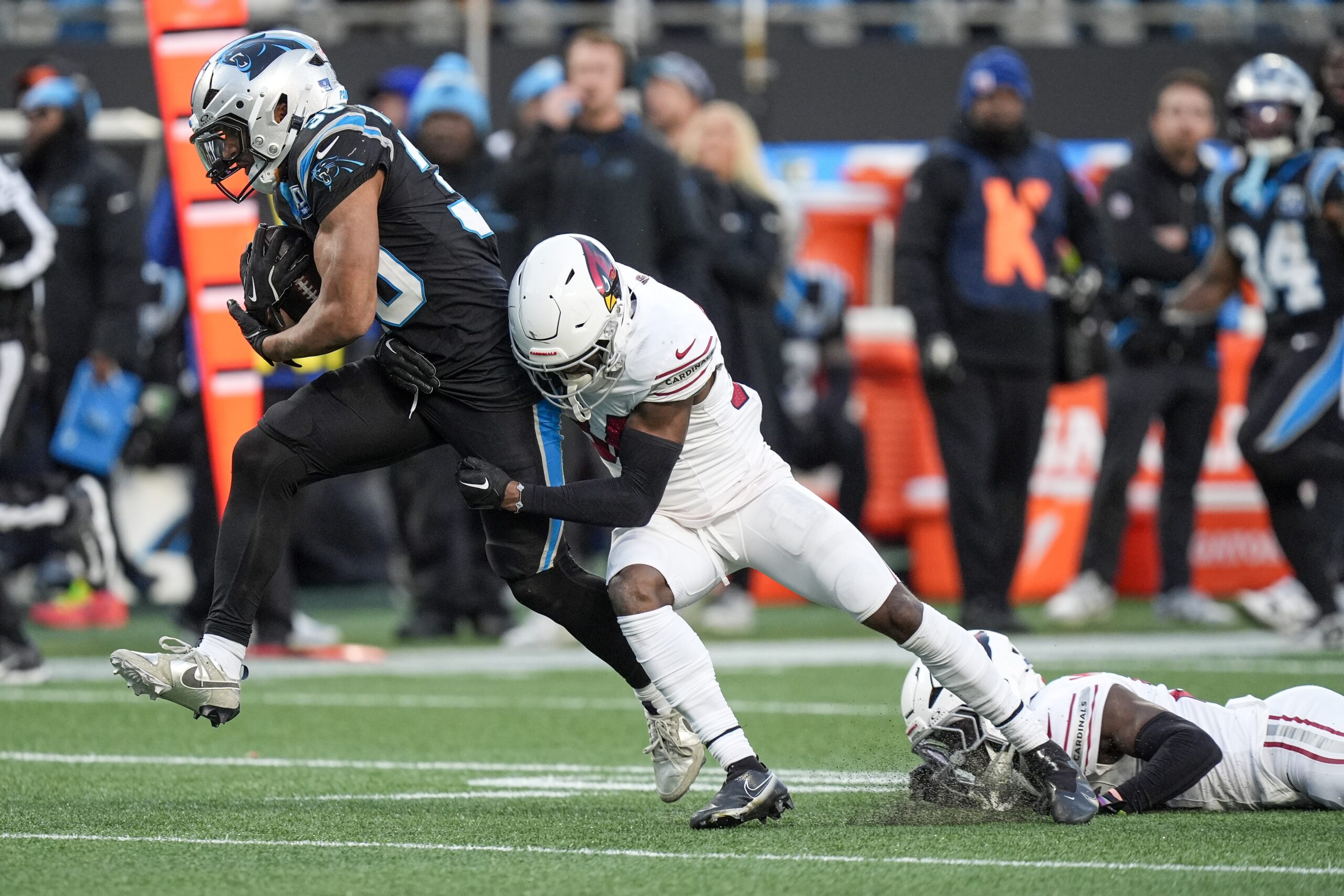 Dec 22, 2024; Charlotte, North Carolina, USA; Carolina Panthers running back Chuba Hubbard (30) tries to evade Arizona Cardinals safety Jalen Thompson (34) during the second half at Bank of America Stadium. Mandatory Credit: Jim Dedmon-Imagn Images