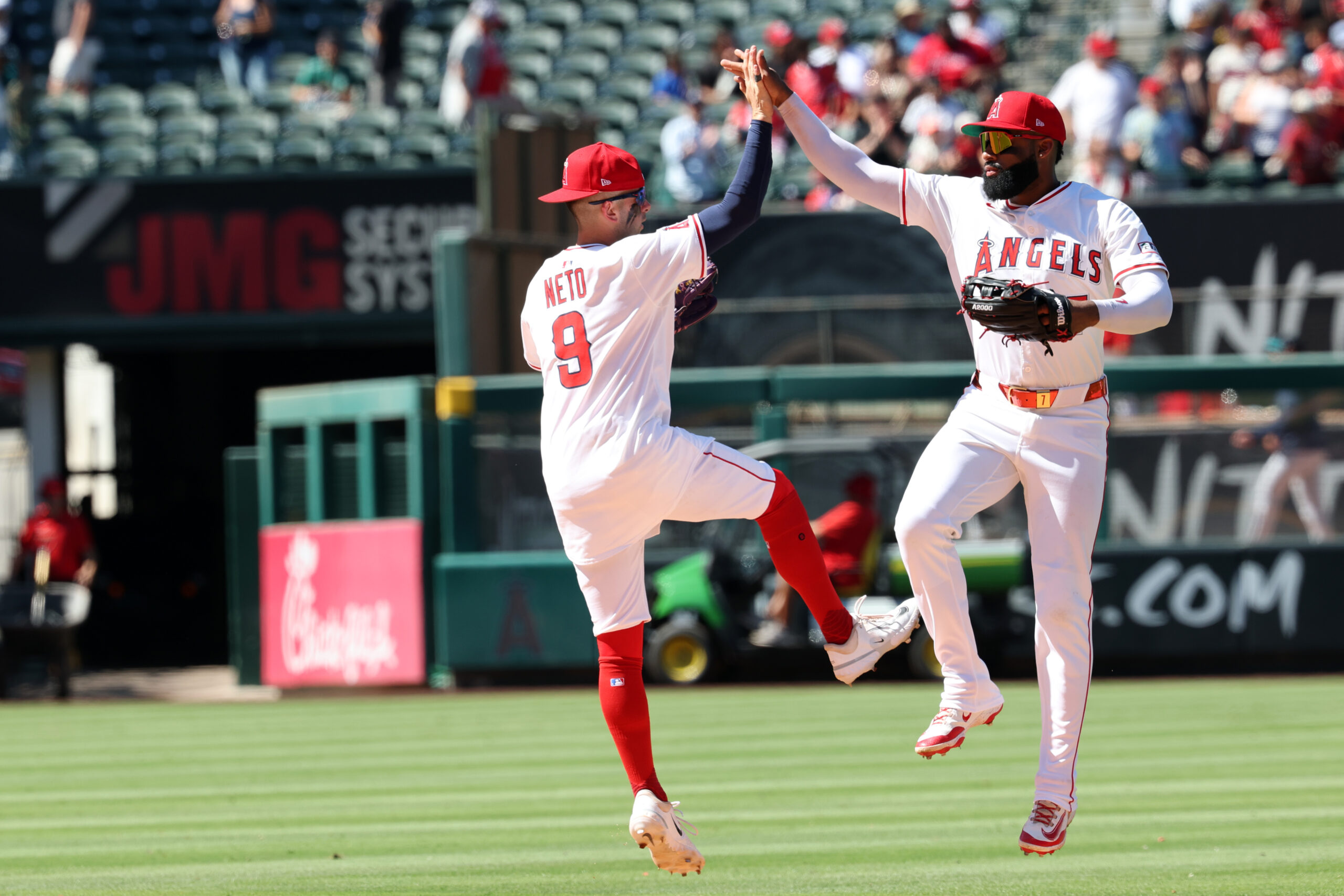 Jul 27, 2025; Anaheim, California, USA; Los Angeles Angels shortstop Zach Neto (9) and center fielder Jo Adell (7) celebrate a win after defeating the Seattle Mariners 4-1 at Angel Stadium. Mandatory Credit: Kiyoshi Mio-Imagn Images