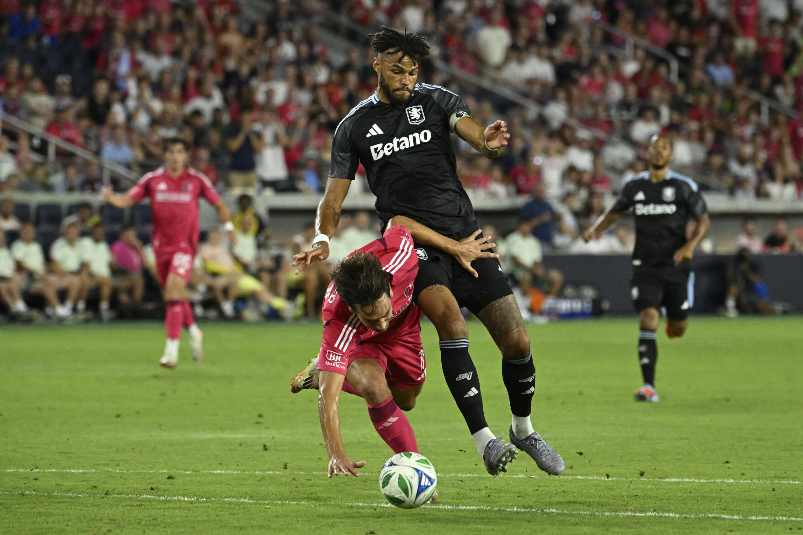 Jul 30, 2025; St. Louis, Missouri, USA; St. Louis City forward Simon Becher (11) falls to the pitch while battling Aston Villa defender Tyrone Mings (5) for the ball in the second half at Energizer Park. Mandatory Credit: Joe Puetz-Imagn Images