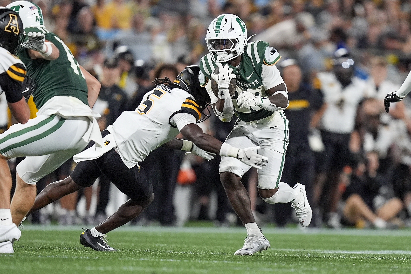 Aug 29, 2025; Charlotte, North Carolina, USA; Charlotte 49ers running back CJ Stokes (23) is tackled by Appalachian State Mountaineers defensive back Zyeir Gamble (5) during the second half at Bank of America Stadium. Mandatory Credit: Jim Dedmon-Imagn Images