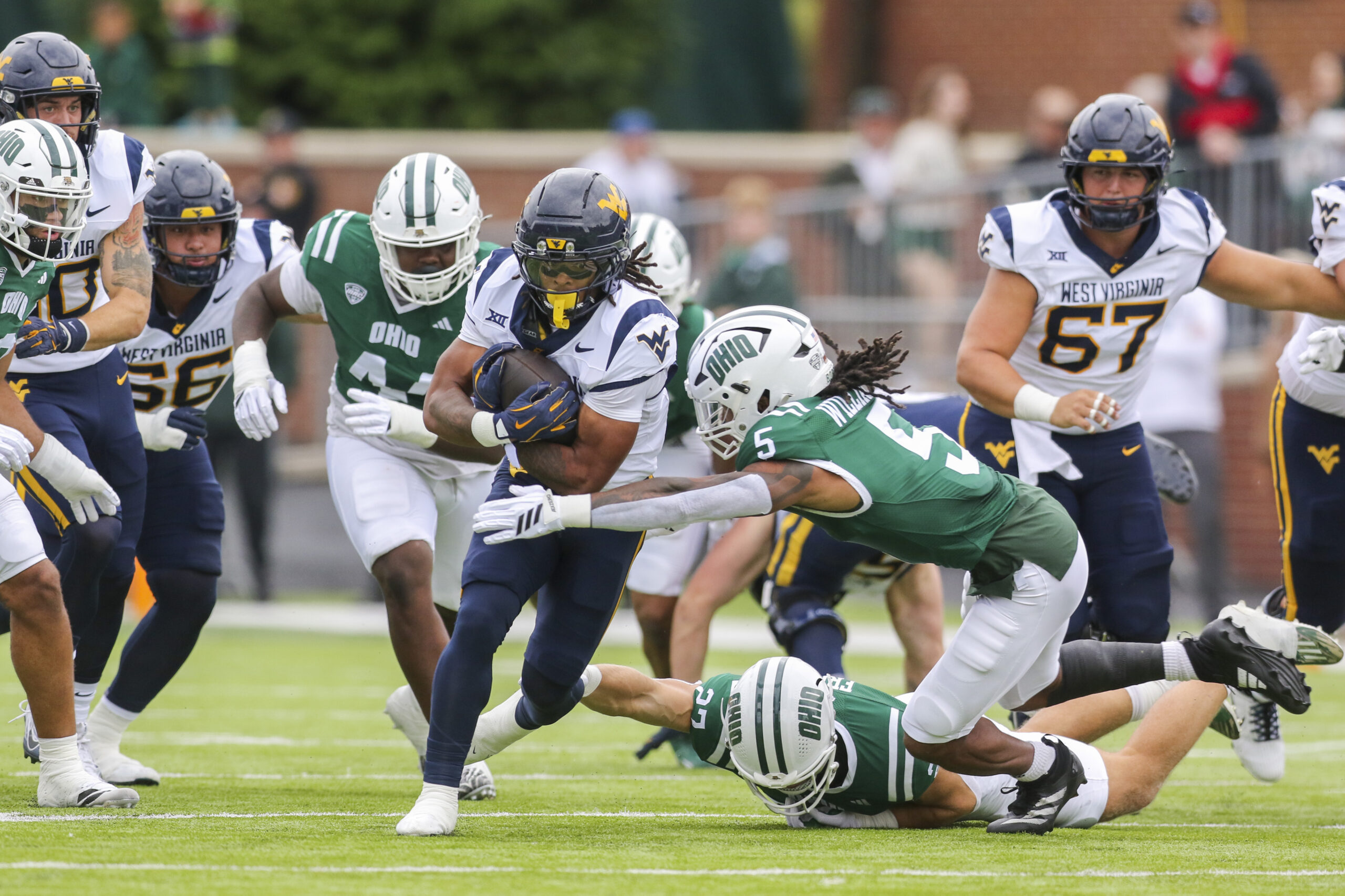 Sep 6, 2025; Athens, Ohio, USA; West Virginia Mountaineers running back Jahiem White (1) runs the ball and is tackled by Ohio Bobcats safety Adonis Williams Jr. (5) during the first quarter at Peden Stadium. Mandatory Credit: Ben Queen-Imagn Images