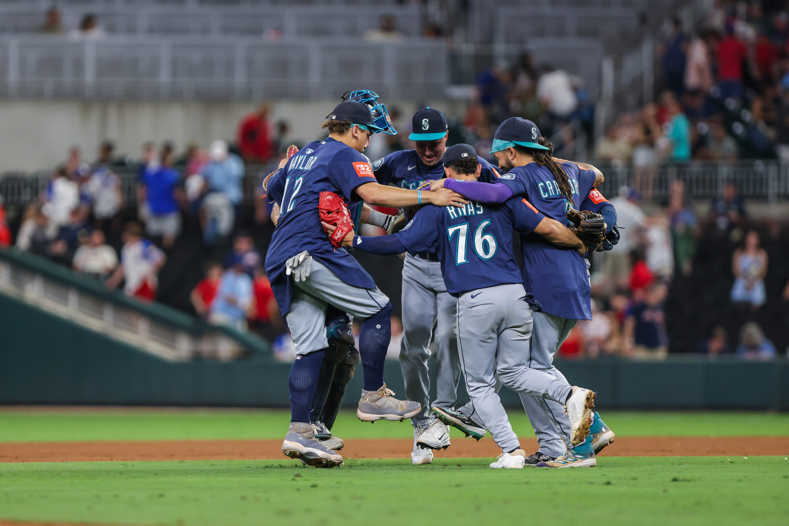 Sep 6, 2025; Cumberland, Georgia, USA; Seattle Mariners catcher Cal Raleigh (29), first base Josh Naylor (12), second base Leo Rivas (76), and shortstop J.P. Crawford (3) celebrate a victory against the Atlanta Braves after the game at Truist Park. Mandatory Credit: Jordan Godfree-Imagn Images