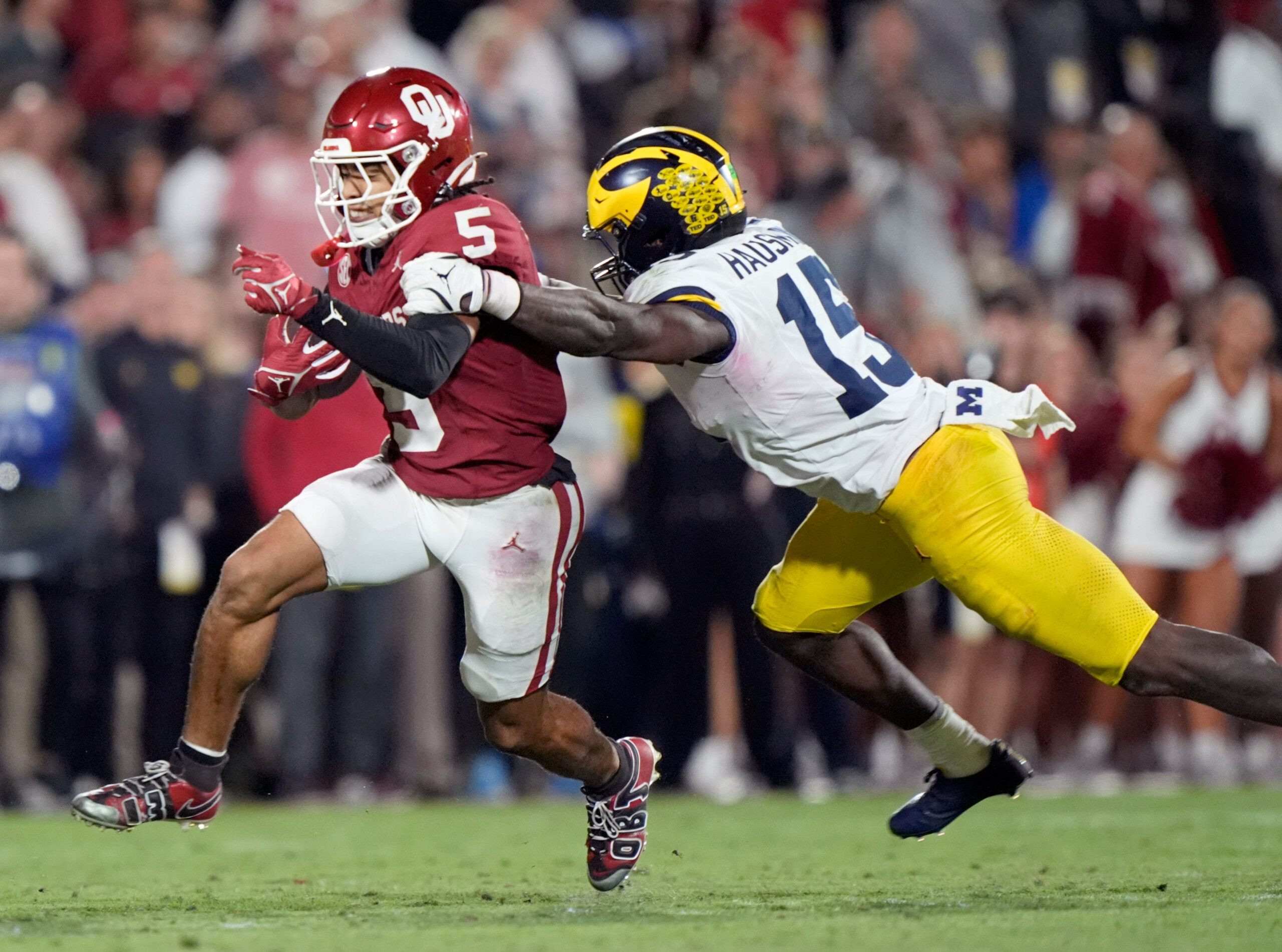 Oklahoma's Isaiah Sategna III (5) get by Michigan's Ernest Hausmann (15) in the second half of the college football game between the University of Oklahoma Sooner and the University of Michigan Wolverines at the Gaylord Family Ð Oklahoma Memorial Stadium in Norman, Okla., Saturday, Sept. 6, 2025.