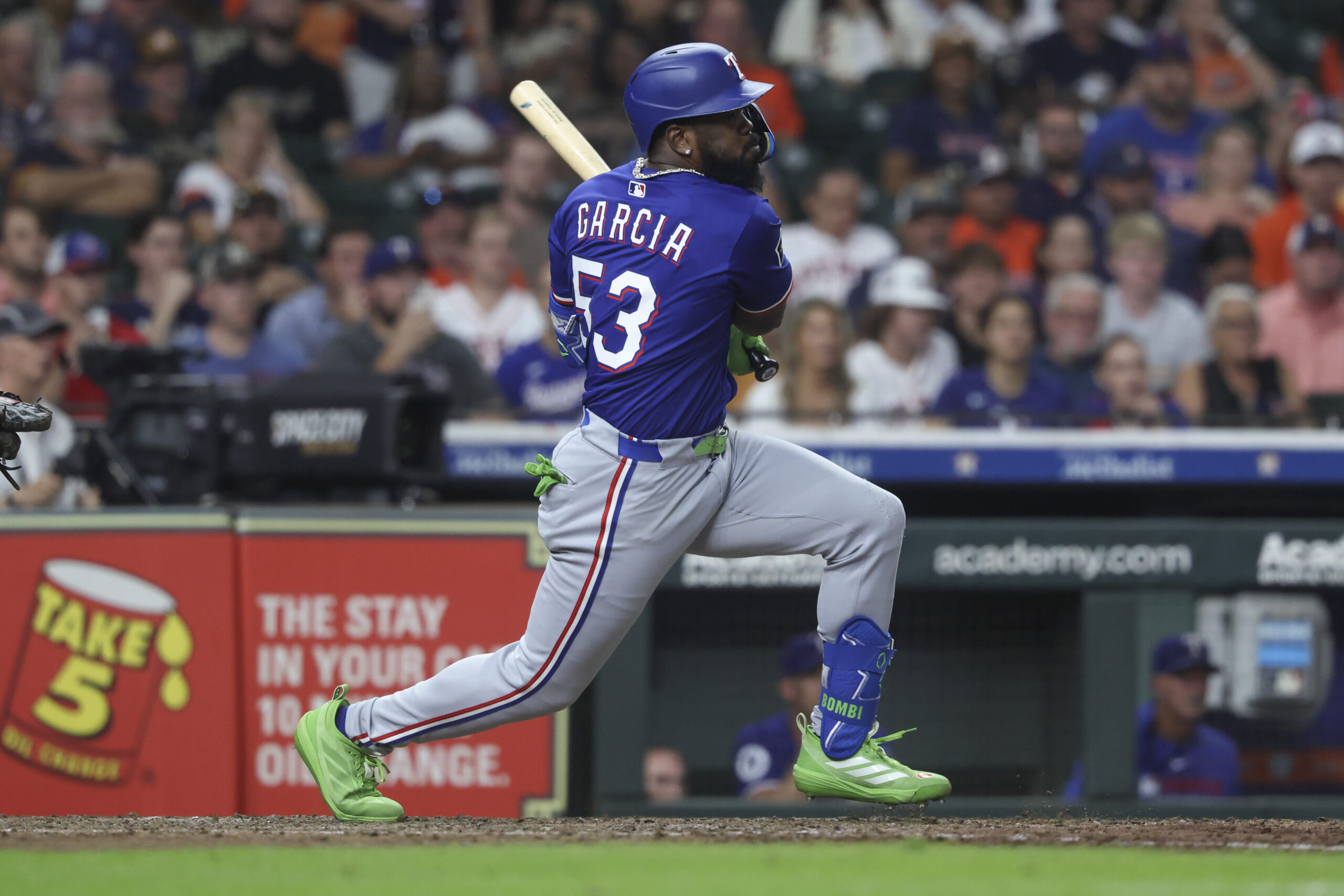 Sep 16, 2025; Houston, Texas, USA; Texas Rangers pinch hitter Adolis Garcia hits an RBI single during the eighth inning against the Houston Astros at Daikin Park. Mandatory Credit: Troy Taormina-Imagn Images