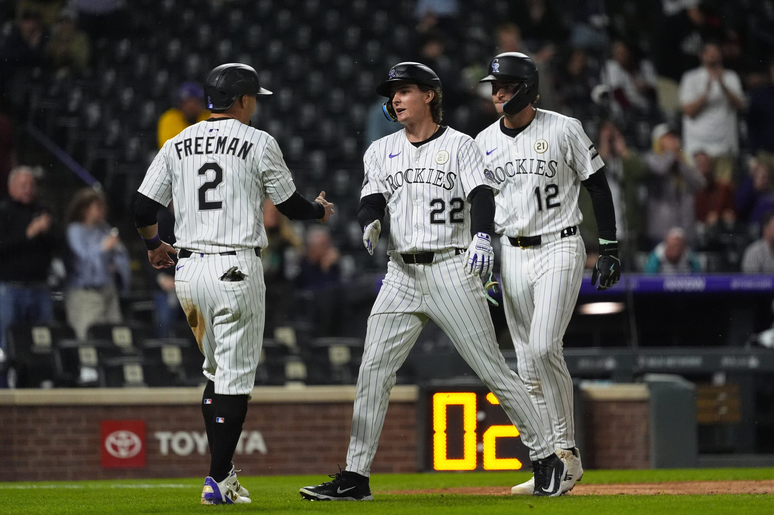 Sep 16, 2025; Denver, Colorado, USA; Colorado Rockies right fielder Mickey Moniak (22) celebrates his three run home run in the eighth inning with designated hitter fielder Tyler Freeman (2) and third baseman Kyle Karros (12) against the Miami Marlins at Coors Field. Mandatory Credit: Ron Chenoy-Imagn Images