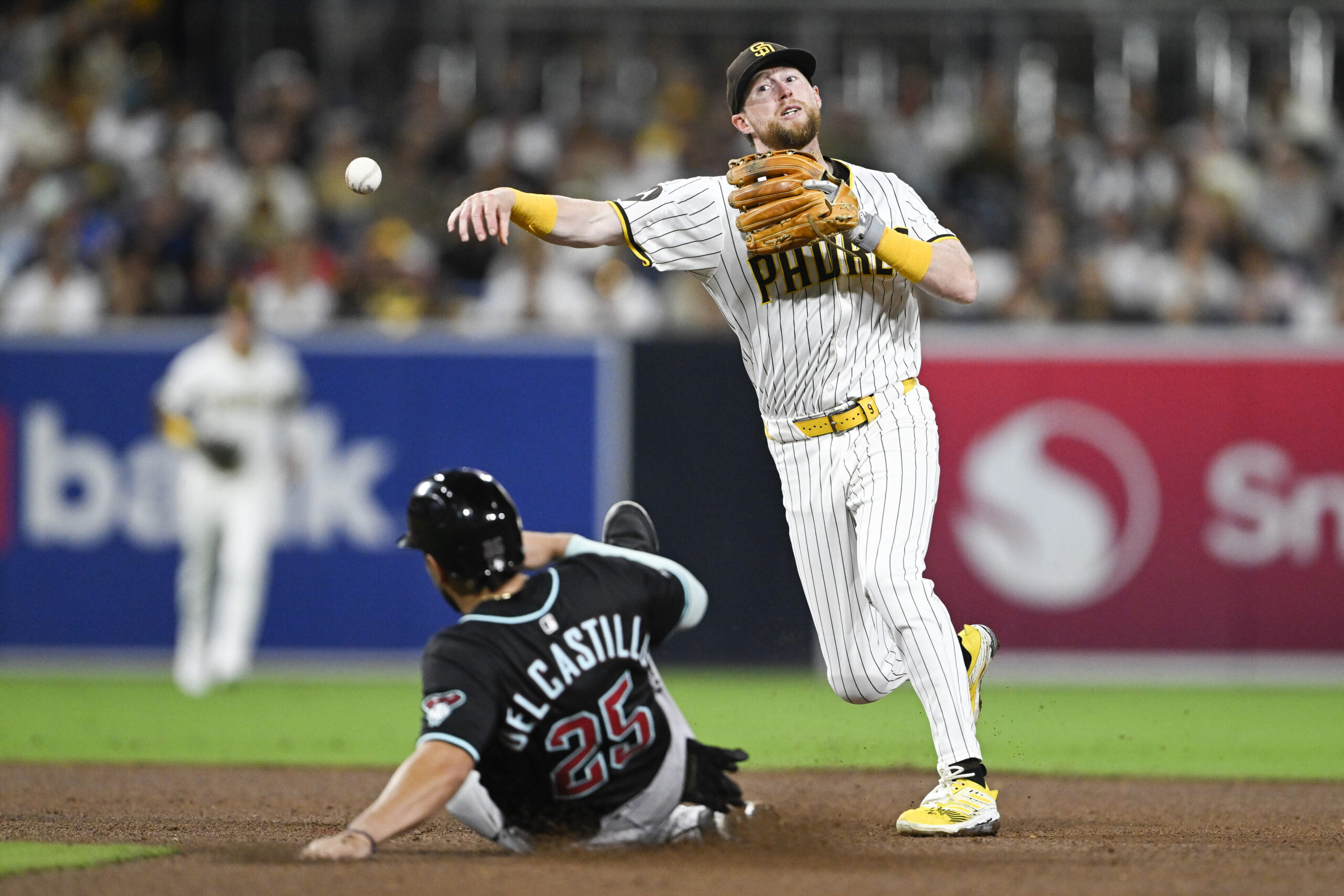Sep 27, 2025; San Diego, California, USA; San Diego Padres second baseman Jake Cronenworth (9) throws over Arizona Diamondbacks catcher Adrian Del Castillo (25) as he turns a double play during the fifth inning at Petco Park. Mandatory Credit: Denis Poroy-Imagn Images