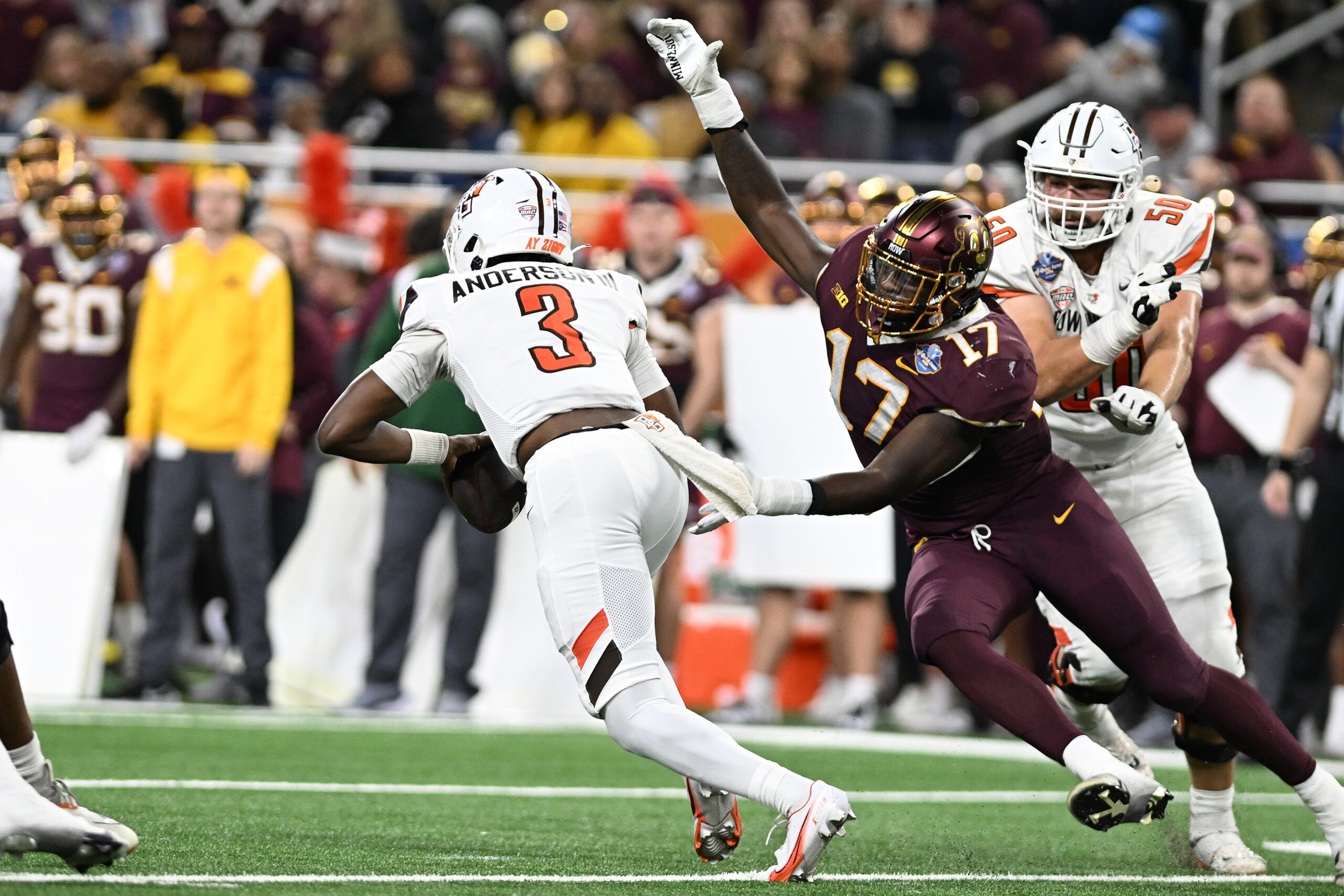 Dec 26, 2023; Detroit, MI, USA; Bowling Green Falcons quarterback Lucian Anderson III (3) scrambles away from Minnesota Golden Gophers defensive lineman Jah Joyner (17) in the second quarter at Ford Field. Mandatory Credit: Lon Horwedel-Imagn Images
