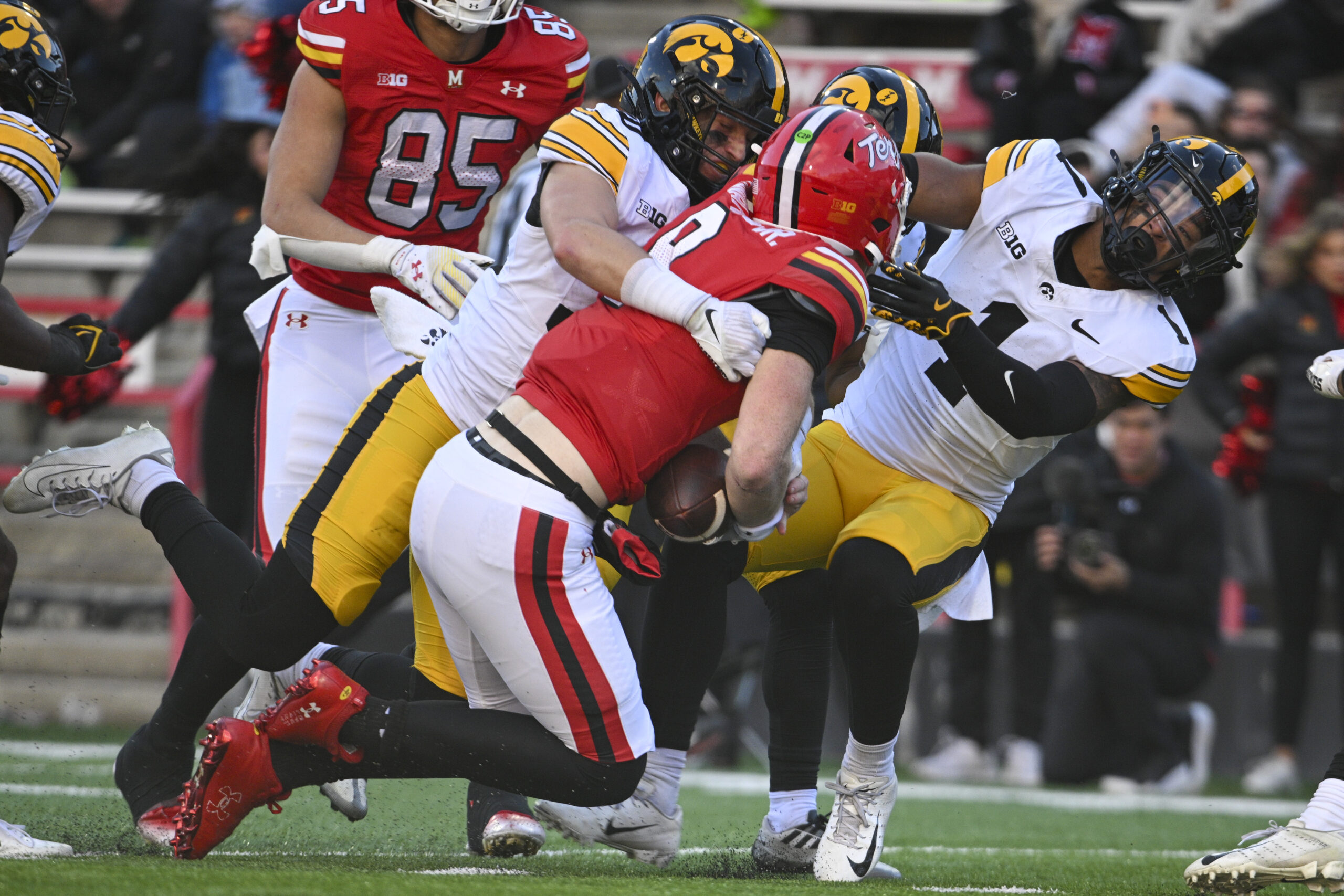 Nov 23, 2024; College Park, Maryland, USA;  Maryland Terrapins quarterback Billy Edwards Jr. (9) hits Iowa Hawkeyes defensive back Xavier Nwankpa (1) as defensive back Quinn Schulte (30) tackles during the second  half at SECU Stadium. Mandatory Credit: Tommy Gilligan-Imagn Images