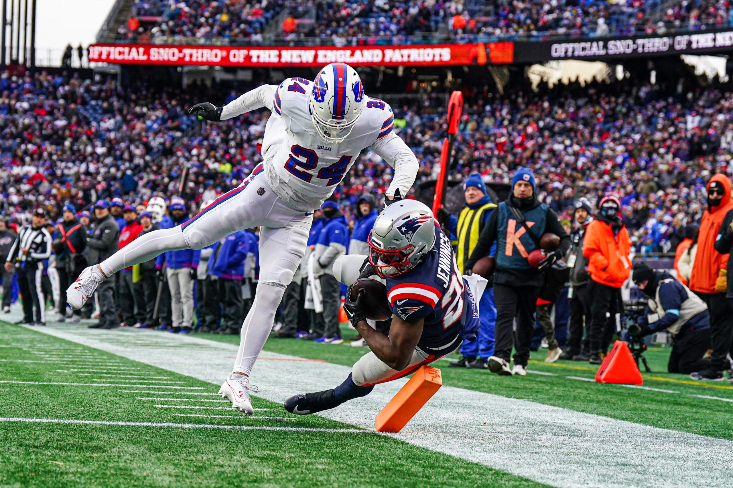 Jan 5, 2025; Foxborough, Massachusetts, USA; New England Patriots running back Terrell Jennings (26) looses control of the ball in the end zone against Buffalo Bills safety Cole Bishop (24) in the second half at Gillette Stadium. Mandatory Credit: David Butler II-Imagn Images
