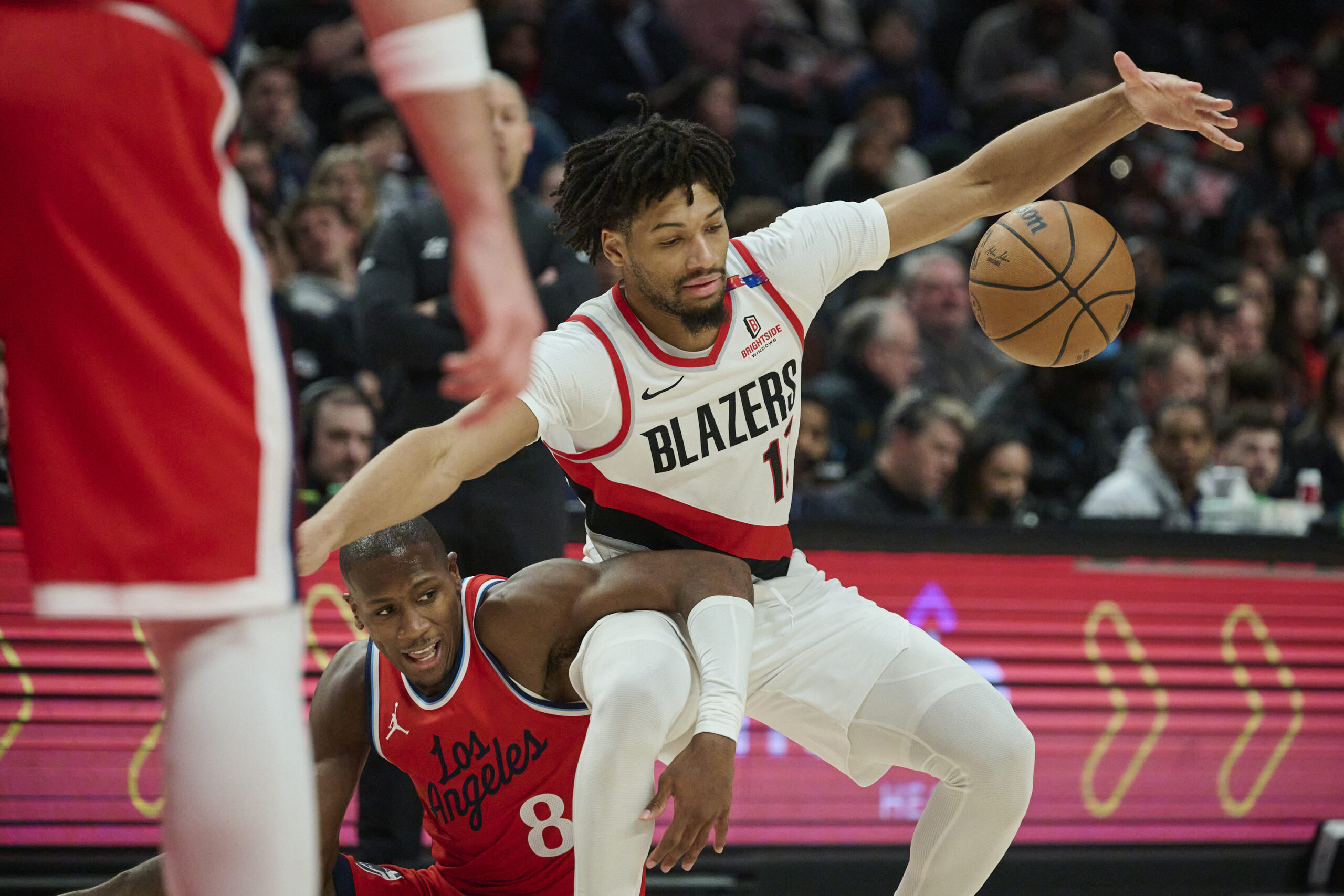 Jan 16, 2025; Portland, Oregon, USA; Portland Trail Blazers guard Shaedon Sharpe (17) and LA Clippers guard Kris Dunn (8) get tangled up chasing a loose ball during the second half at Moda Center. Mandatory Credit: Troy Wayrynen-Imagn Images