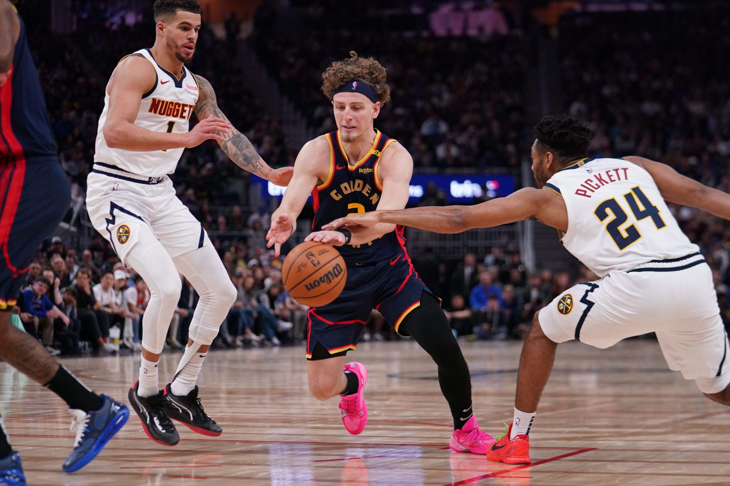 Apr 4, 2025; San Francisco, California, USA;  Golden State Warriors guard Brandin Podziemski (2) dribbles by Denver Nuggets forward Michael Porter Jr. (1) and Denver Nuggets guard Jalen Pickett (24) in the third period at Chase Center. Mandatory Credit: David Gonzales-Imagn Images