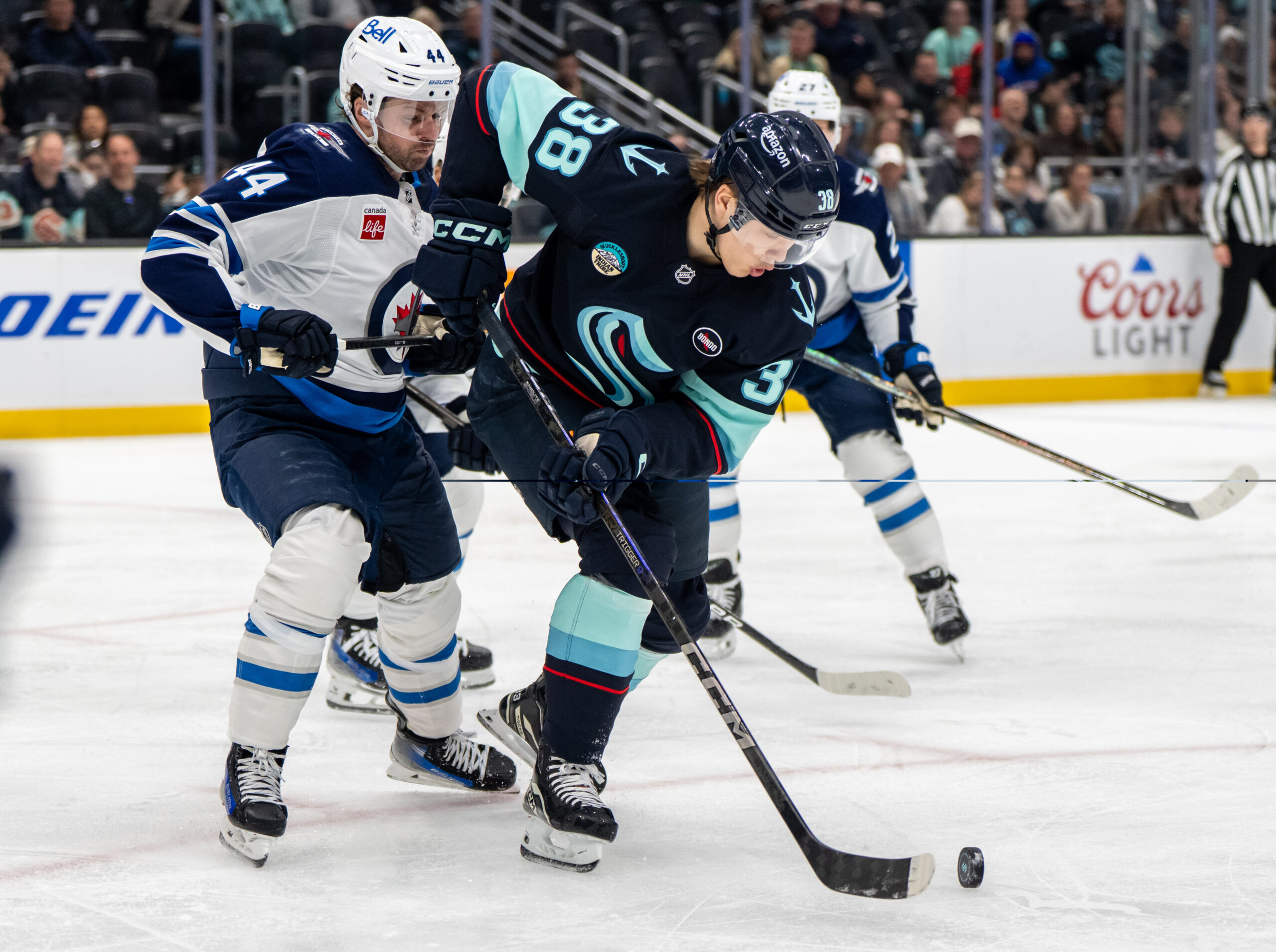 Mar 16, 2025; Seattle, Washington, USA;  Seattle Kraken foward Jani Nyman (38) skates against Winnipeg Jets defenseman Josh Morrissey (44) at Climate Pledge Arena. Mandatory Credit: Stephen Brashear-Imagn Images
