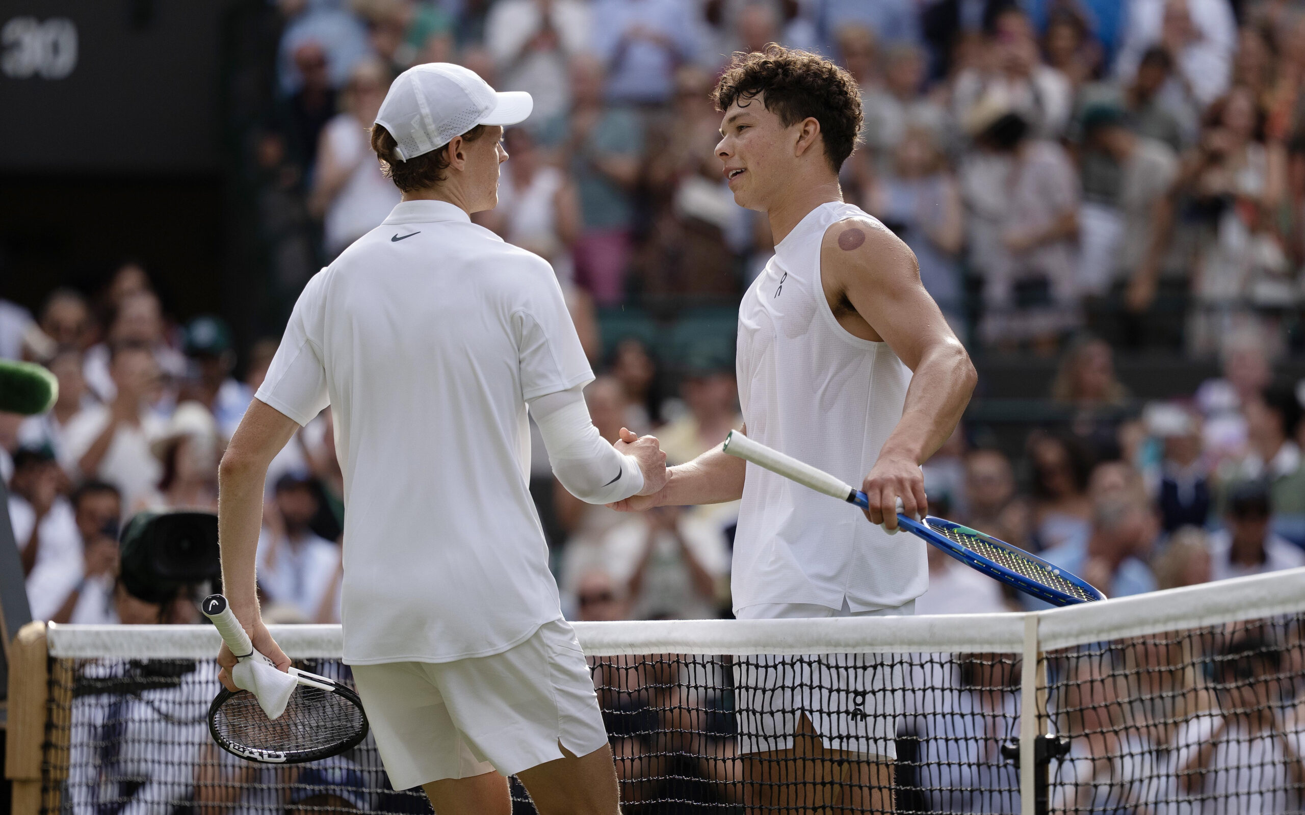 Jul 9, 2025; Wimbledon, United Kingdom; Jannik Sinner of Italy at the net with Ben Shelton of the United States after their match on day 10 at All England Lawn Tennis and Croquet Club. Mandatory Credit: Susan Mullane-Imagn Images