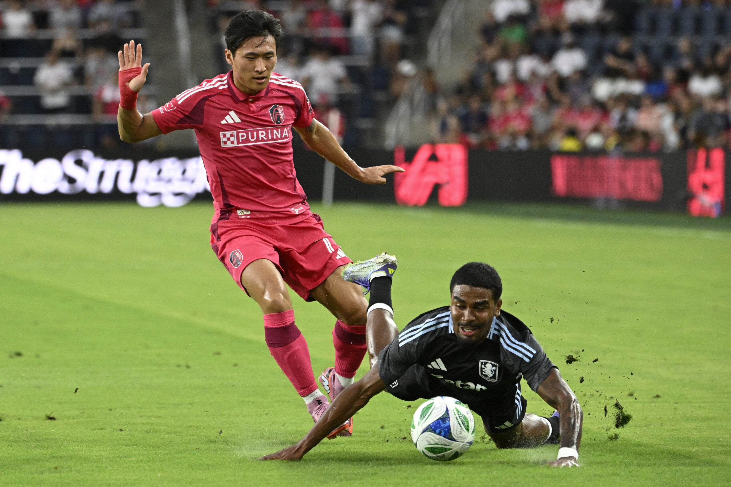 Jul 30, 2025; St. Louis, Missouri, USA; Aston Villa defender Ian Maatsen (22) falls to the pitch after battle St. Louis City forward Jeong Sang-Bin (77) for the ball in the first half at Energizer Park. Mandatory Credit: Joe Puetz-Imagn Images