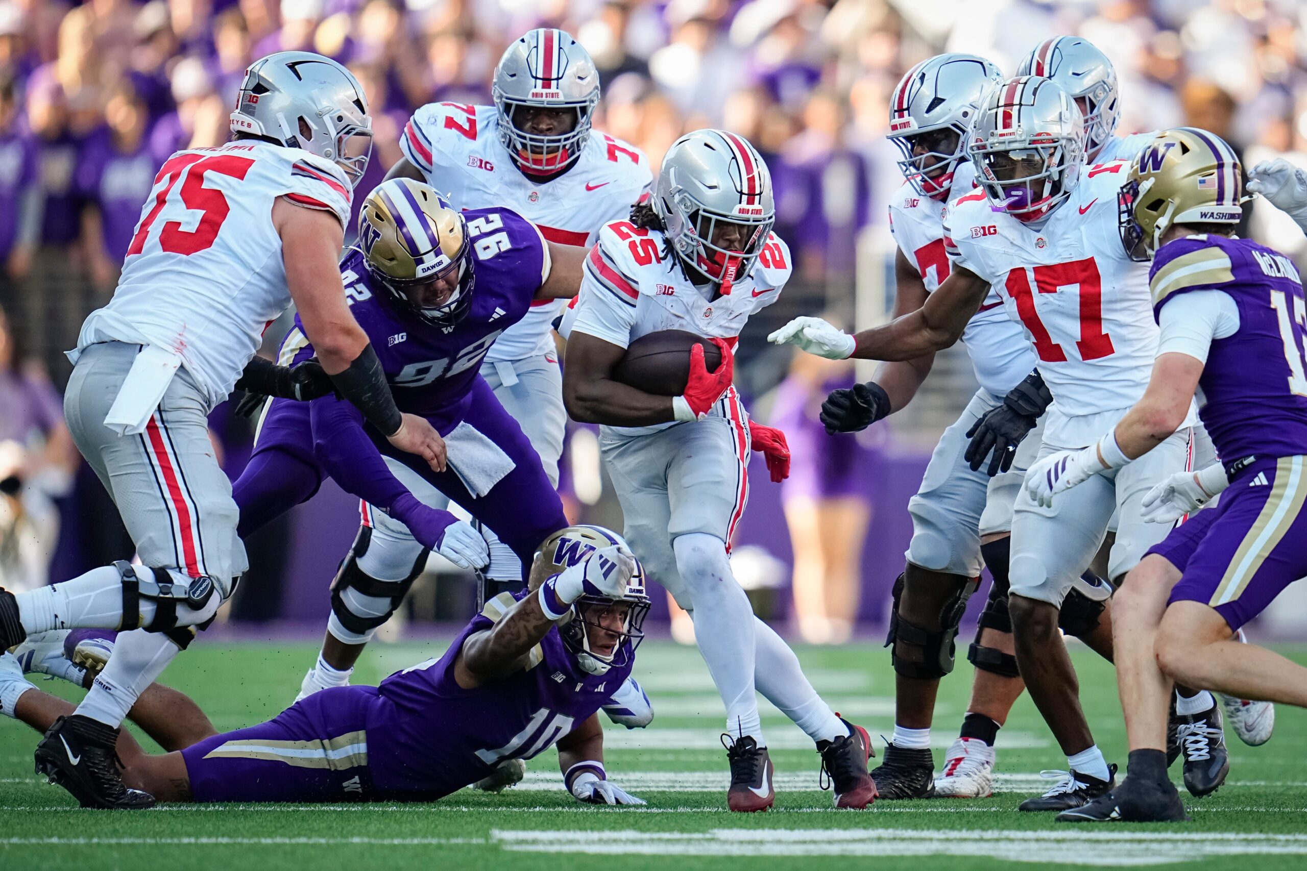 Ohio State Buckeyes running back Bo Jackson (25) runs over Washington Huskies linebacker Xe'ree Alexander (10) and defensive lineman Bryce Butler (92) during the NCAA football game at Husky Stadium in Seattle on Sept. 27, 2025. Ohio State won 24-6.