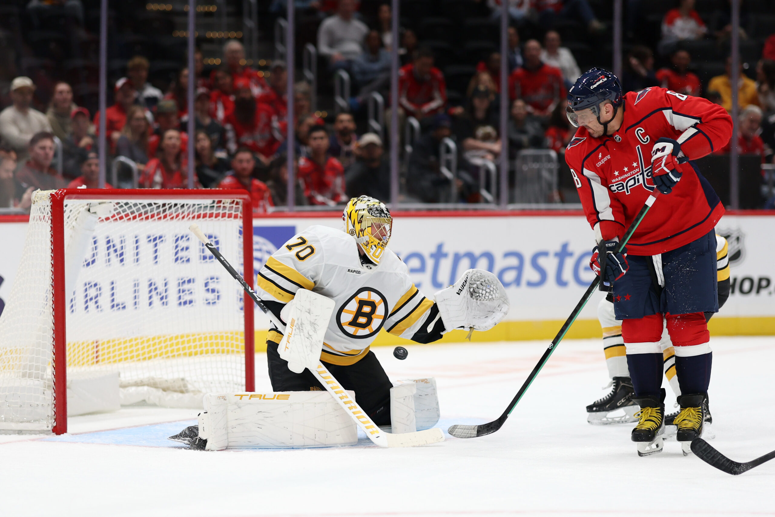 Oct 2, 2025; Washington, District of Columbia, USA; Washington Capitals left wing Alex Ovechkin (8) deflects the puck on Boston Bruins goaltender Joonas Korpisalo (70) in the first period at Capital One Arena. Mandatory Credit: Geoff Burke-Imagn Images