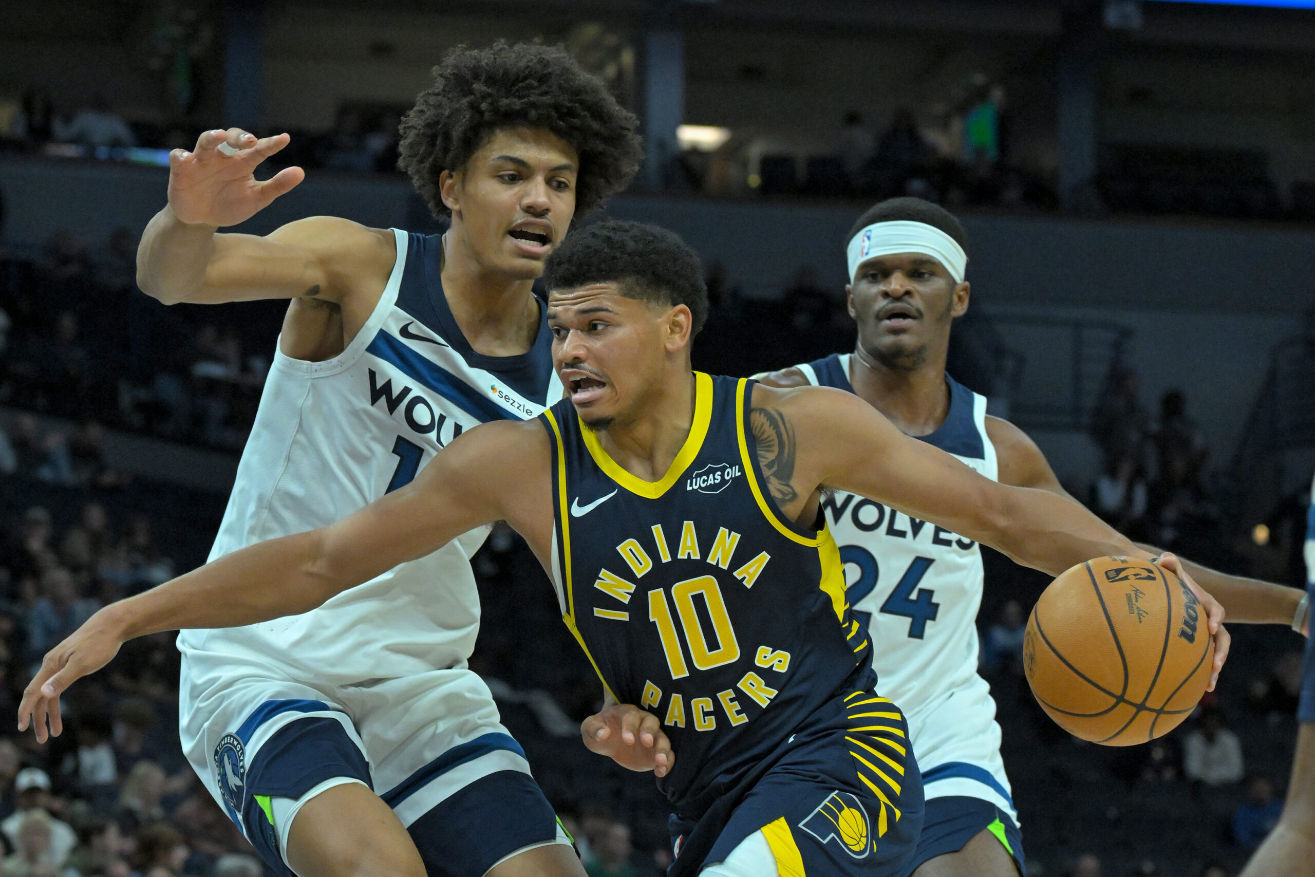 Oct 7, 2025; Minneapolis, Minnesota, USA; Indiana Pacers guard RayJ Dennis (10) drives the lane as Minnesota Timberwolves center Joan Beringer (19) defends during the fourth quarter at Target Center. Mandatory Credit: Nick Wosika-Imagn Images