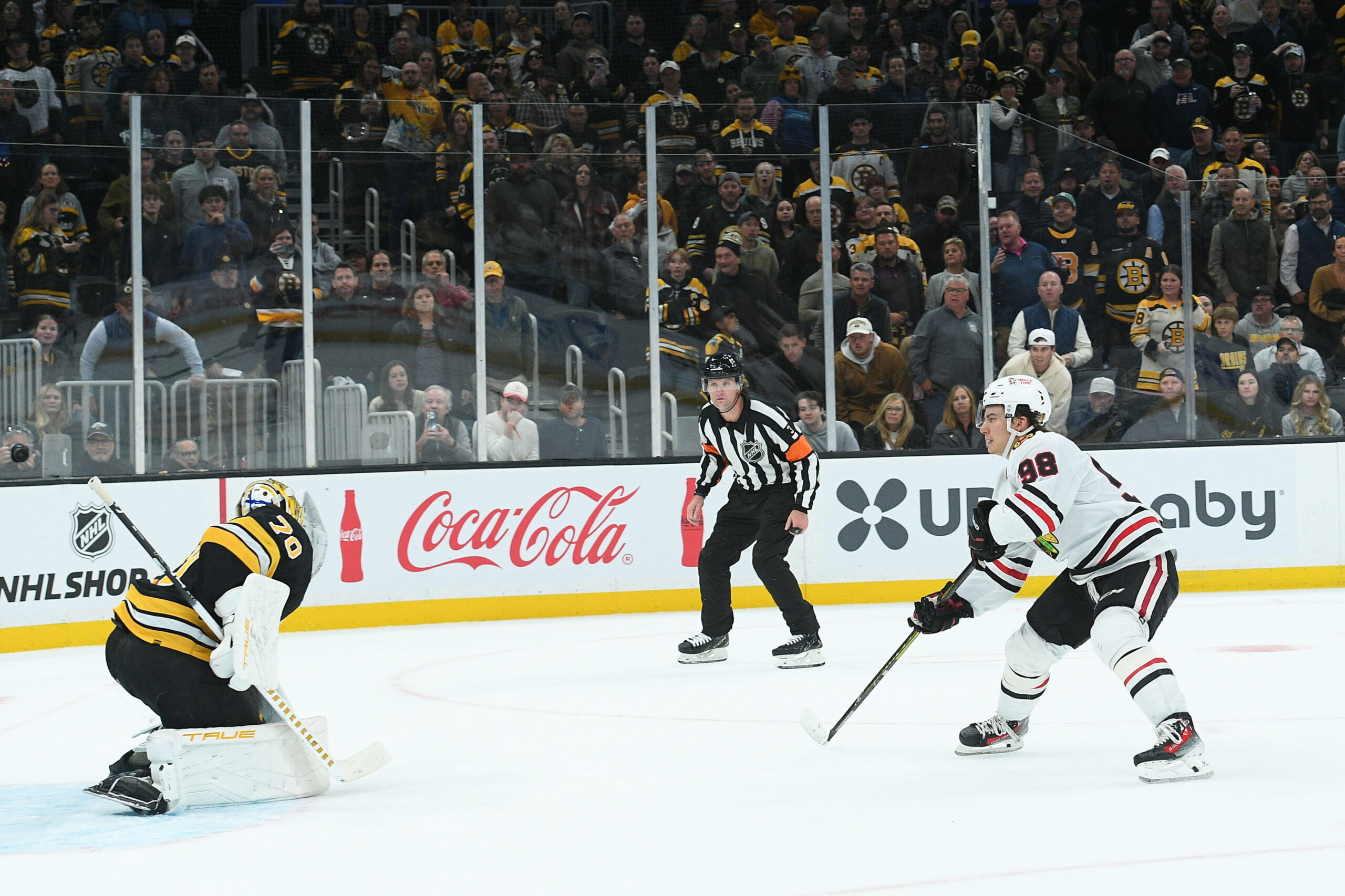 Oct 9, 2025; Boston, Massachusetts, USA; Boston Bruins goaltender Joonas Korpisalo (70) makes a glove save on Chicago Blackhawks center Connor Bedard (98) during overtime at TD Garden. Mandatory Credit: Bob DeChiara-Imagn Images