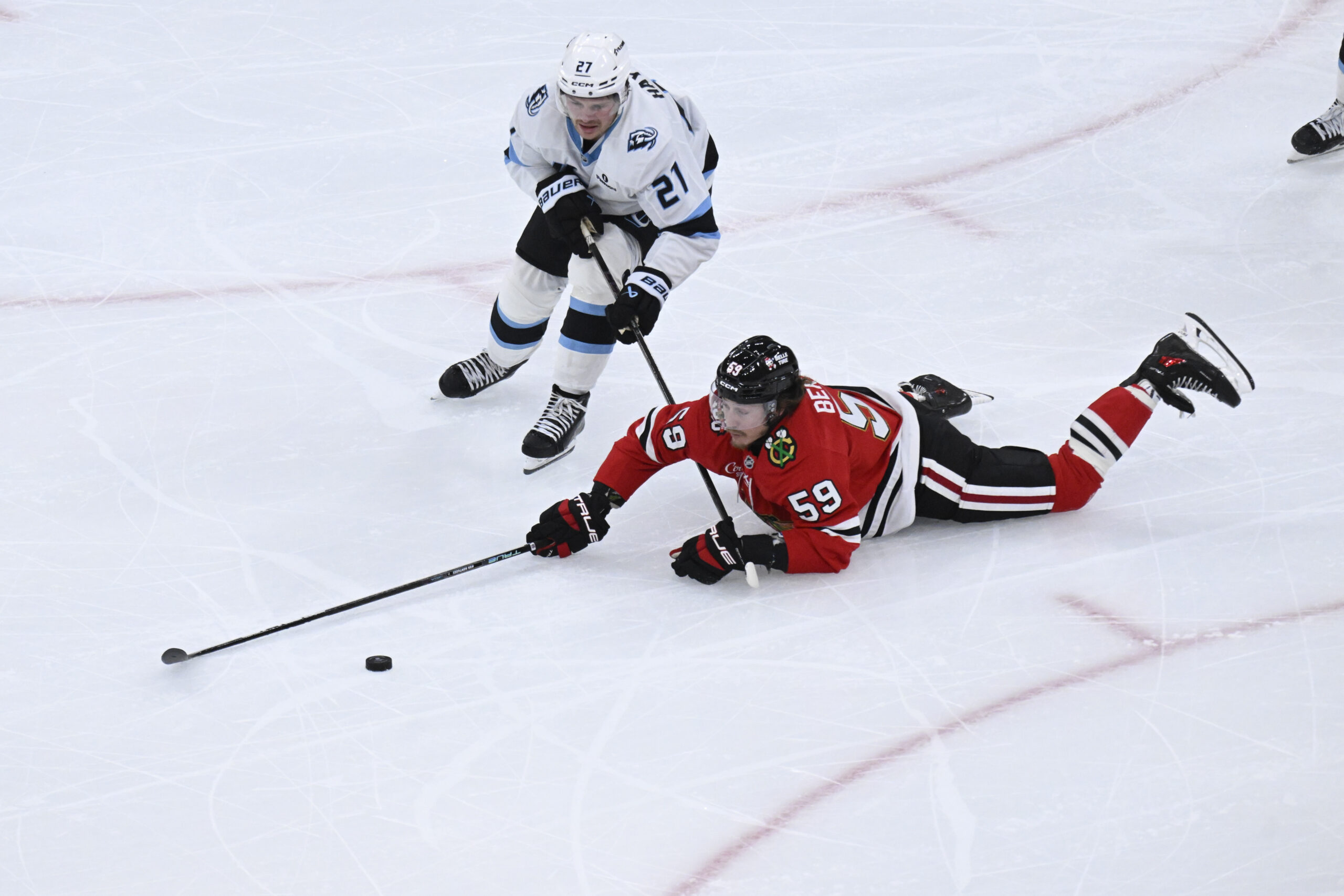 Oct 13, 2025; Chicago, Illinois, USA;  Chicago Blackhawks left wing Tyler Bertuzzi (59) and Utah Mammoth center Barrett Hayton (27) chase the puck during the second period at United Center. Mandatory Credit: Matt Marton-Imagn Images