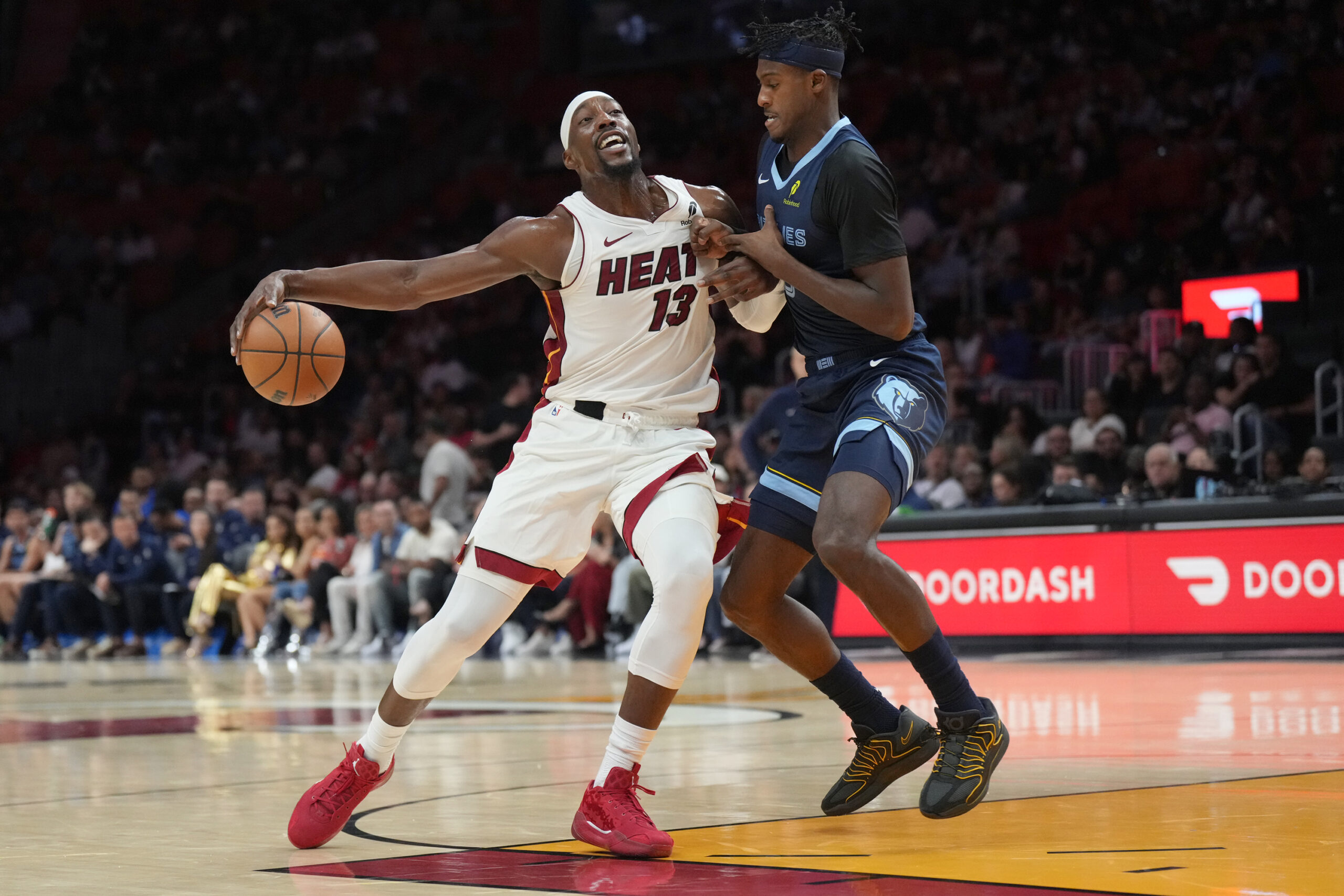 Oct 17, 2025; Miami, Florida, USA;  Memphis Grizzlies forward Olivier-Maxence Prosper (18) collides with Miami Heat center  Bam Adebayo (13) during the first half at Kaseya Center. Mandatory Credit: Jim Rassol-Imagn Images