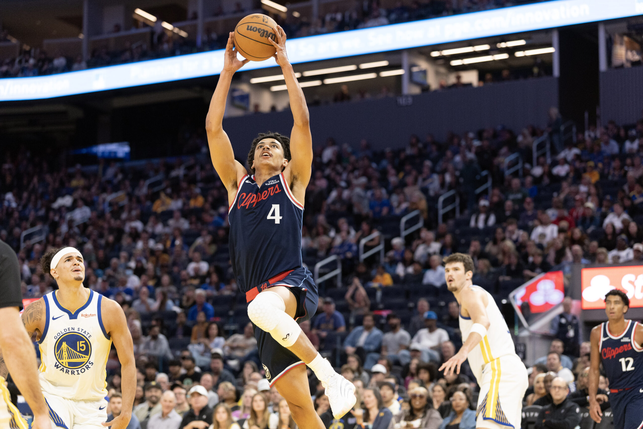Oct 17, 2025; San Francisco, California, USA; Los Angeles Clippers guard Kobe Sanders (4) dunks the ball ahead of Golden State Warriors forward Gui Santos (15) during the third quarter at Chase Center. Mandatory Credit: D. Ross Cameron-Imagn Images