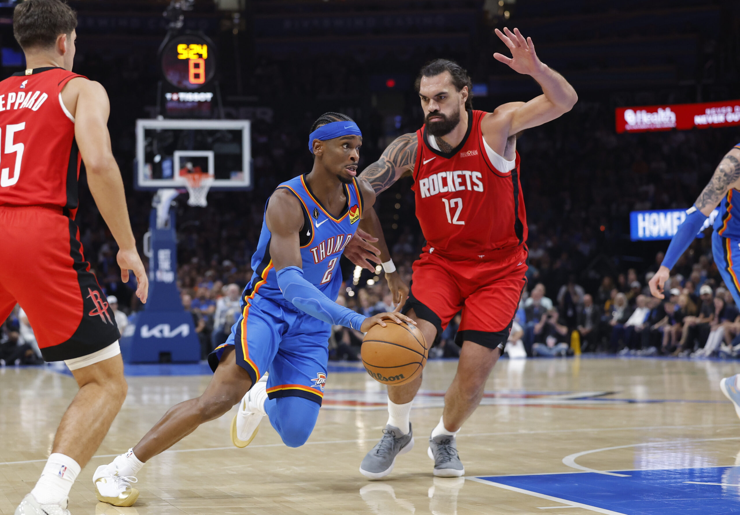 Oct 21, 2025; Oklahoma City, Oklahoma, USA; Oklahoma City Thunder guard Shai Gilgeous-Alexander (2) drives to the basket beside Houston Rockets center Steven Adams (12) during the first half at Paycom Center. Mandatory Credit: Alonzo Adams-Imagn Images