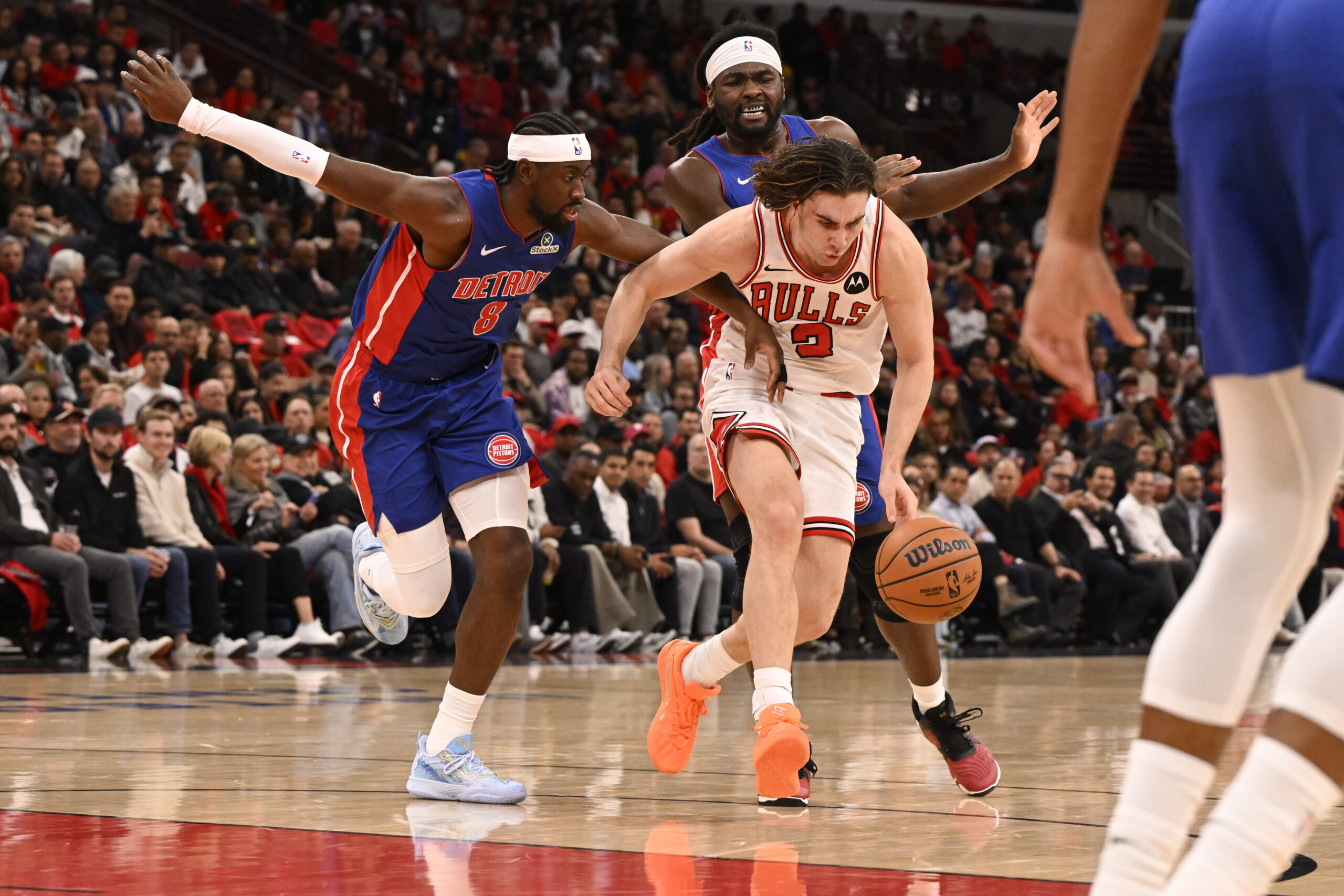 Oct 22, 2025; Chicago, Illinois, USA; Chicago Bulls guard Josh Giddey (3) drives between Detroit Pistons guard Caris LeVert (8) and  forward Isaiah Stewart (28) during the first half at United Center. Mandatory Credit: Matt Marton-Imagn Images