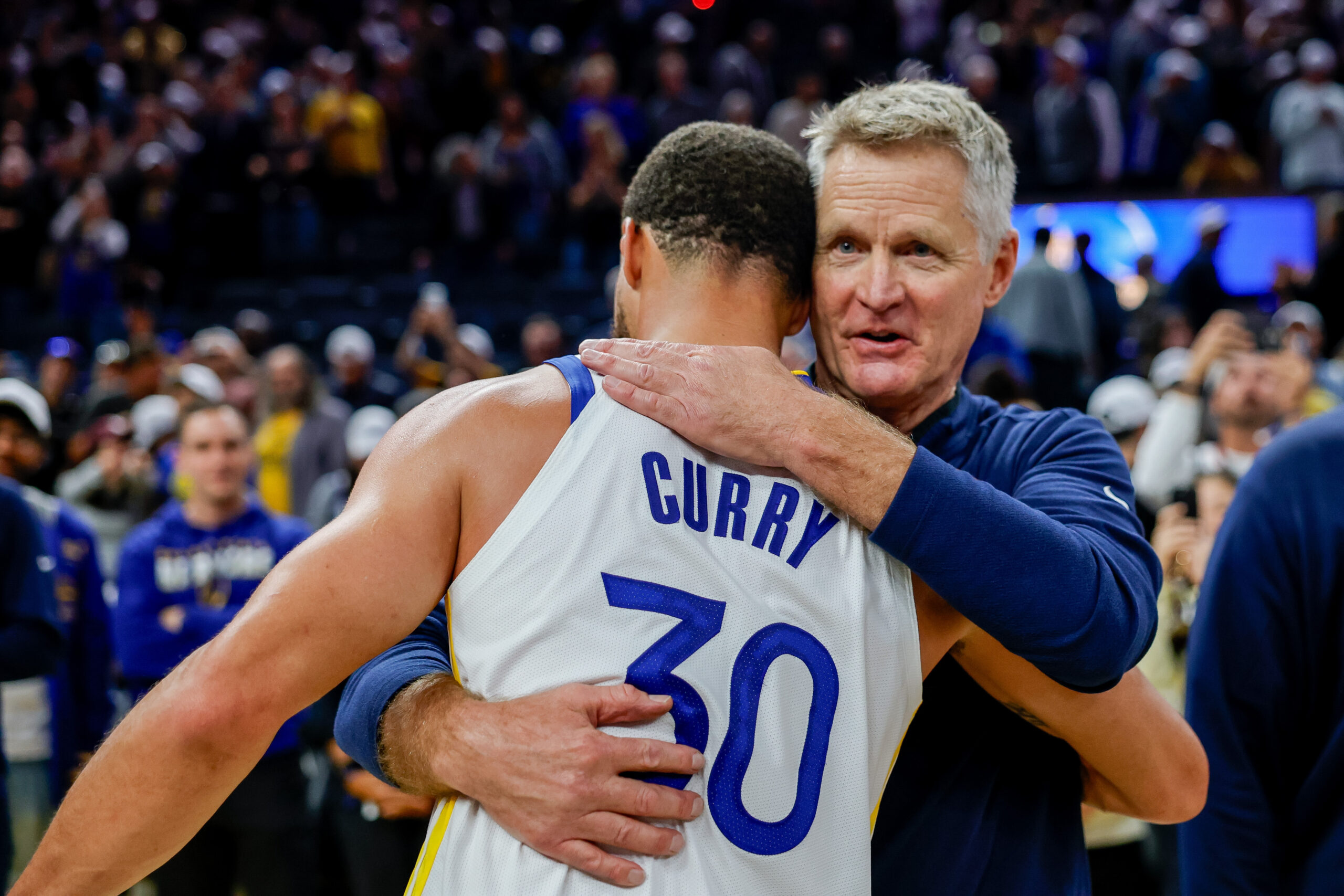 Oct 23, 2025; San Francisco, California, USA; Golden State Warriors guard Stephen Curry (30) embraces head coach Steve Kerr after their overtime win against the Denver Nuggets at Chase Center. Mandatory Credit: Bob Kupbens-Imagn Images