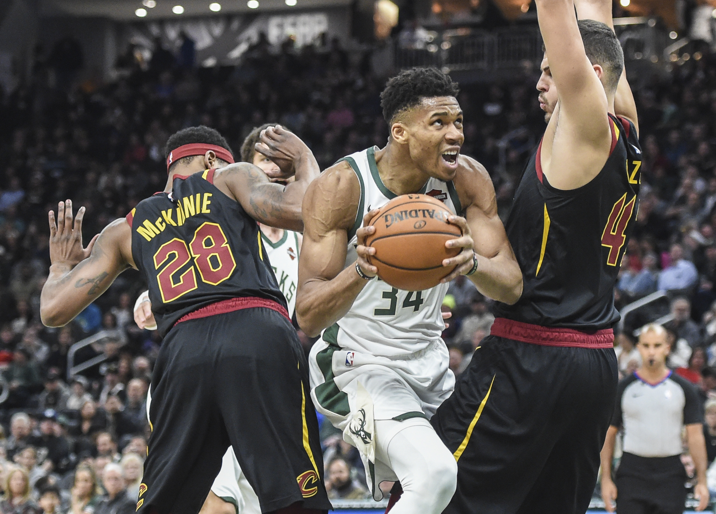 Dec 14, 2019; Milwaukee, WI, USA;  Milwaukee Bucks forward Giannis Antetokounmpo (34) drives for the basket between Cleveland Cavaliers forward Alfonzo McKinnie (28) and center Ante Zizic (41) in the fourth quarter at Fiserv Forum. Mandatory Credit: Benny Sieu-Imagn Images