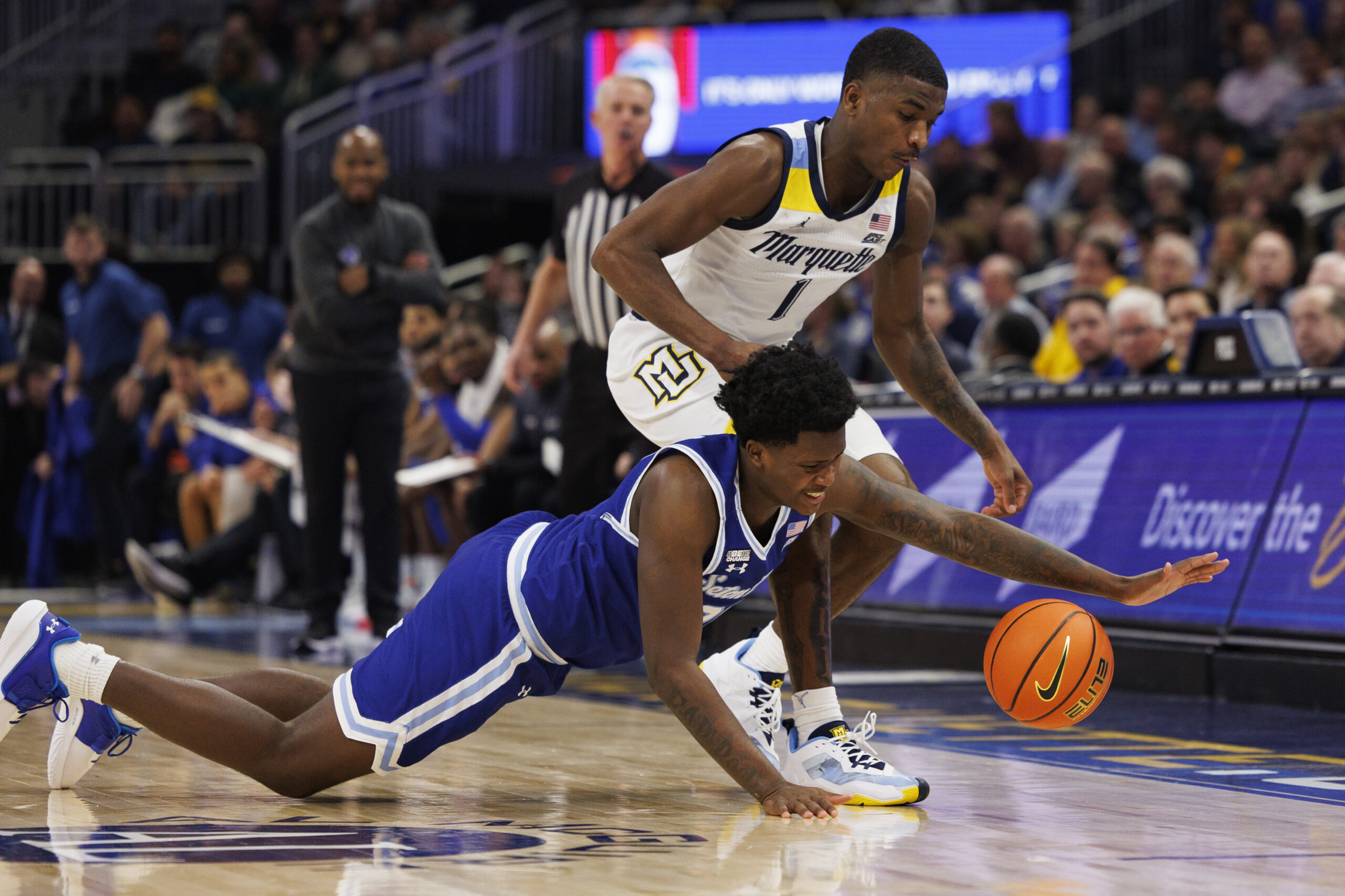 Dec 27, 2022; Milwaukee, Wisconsin, USA; Seton Hall Pirates guard Jaquan Sanders (20) and Marquette Golden Eagles guard Kam Jones (1) chase the loose ball during the first half at Fiserv Forum. Mandatory Credit: Jeff Hanisch-Imagn Images