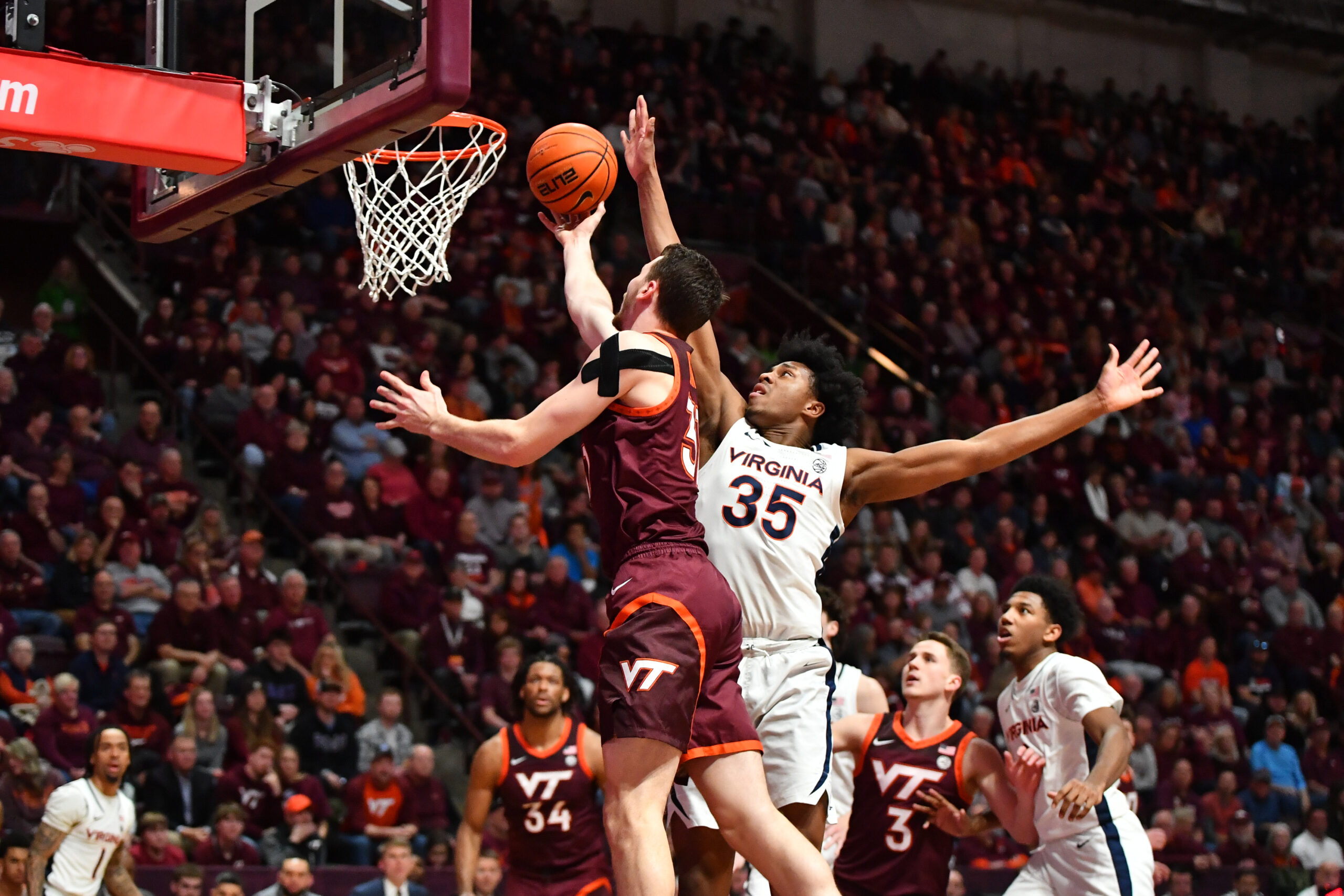 Feb 19, 2024; Blacksburg, Virginia, USA; Virginia Tech Hokies forward Robbie Beran (31) lays the ball up while Virginia Cavaliers guard Leon Bond III (35) defends during the second half at Cassell Coliseum. Mandatory Credit: Brian Bishop-Imagn Images