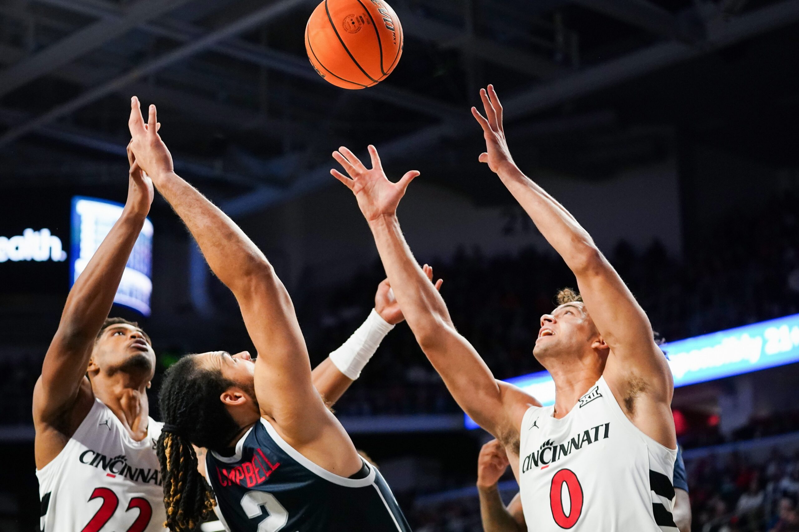 Cincinnati Bearcats forward Arrinten Page (22), Cincinnati Bearcats guard Dan Skillings Jr. (0) and Howard Bison forward Dom Campbell (2) battle to gain possession of a loose ball in the first half of a college basketball game between the Cincinnati Bearcats and Howard Bison, Sunday, Dec. 8, 2024, at Fifth Third Arena in Cincinnati.