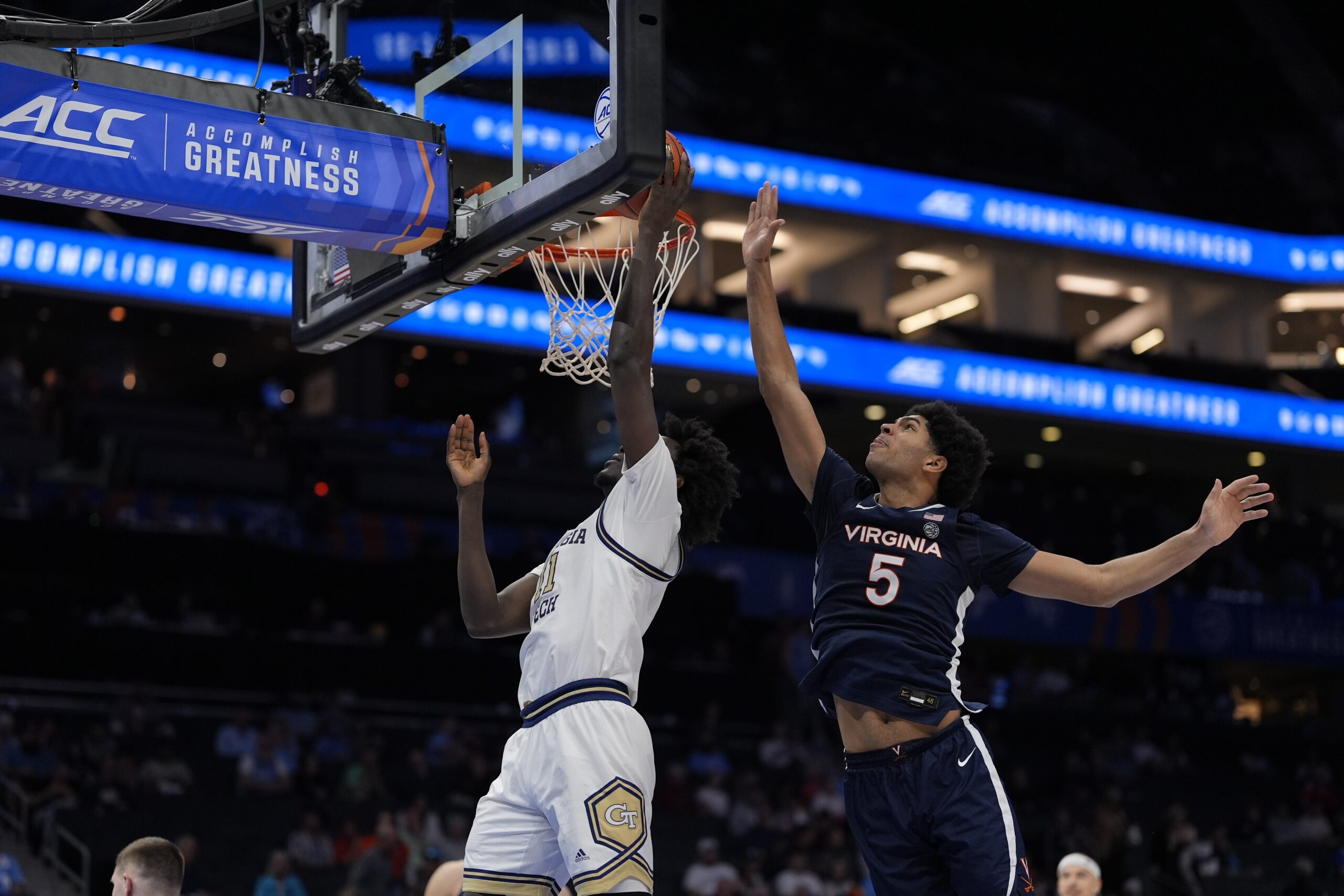 Mar 12, 2025; Charlotte, NC, USA; Georgia Tech Yellow Jackets forward Baye Ndongo (11) goes to the basket defended by Virginia Cavaliers forward Jacob Cofie (5) during the second half at Spectrum Center. Mandatory Credit: Jim Dedmon-Imagn Images