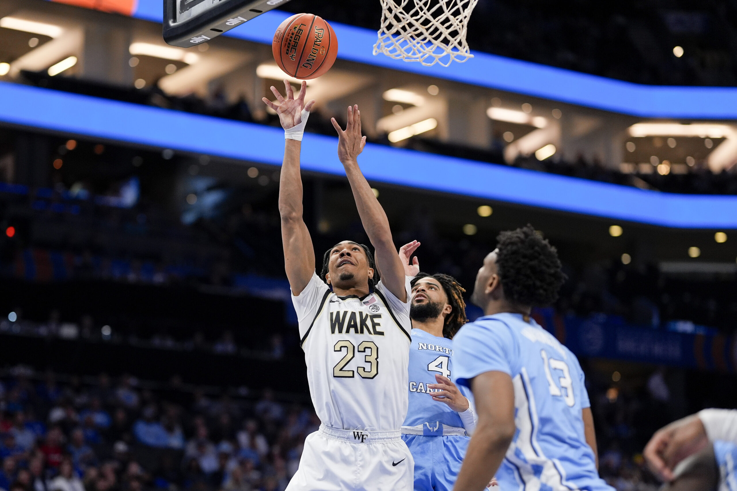 Mar 13, 2025; Charlotte, NC, USA; Wake Forest Demon Deacons guard Hunter Sallis (23) goes to the basket chased by North Carolina Tar Heels guard RJ Davis (4) during the second half at Spectrum Center. Mandatory Credit: Jim Dedmon-Imagn Images