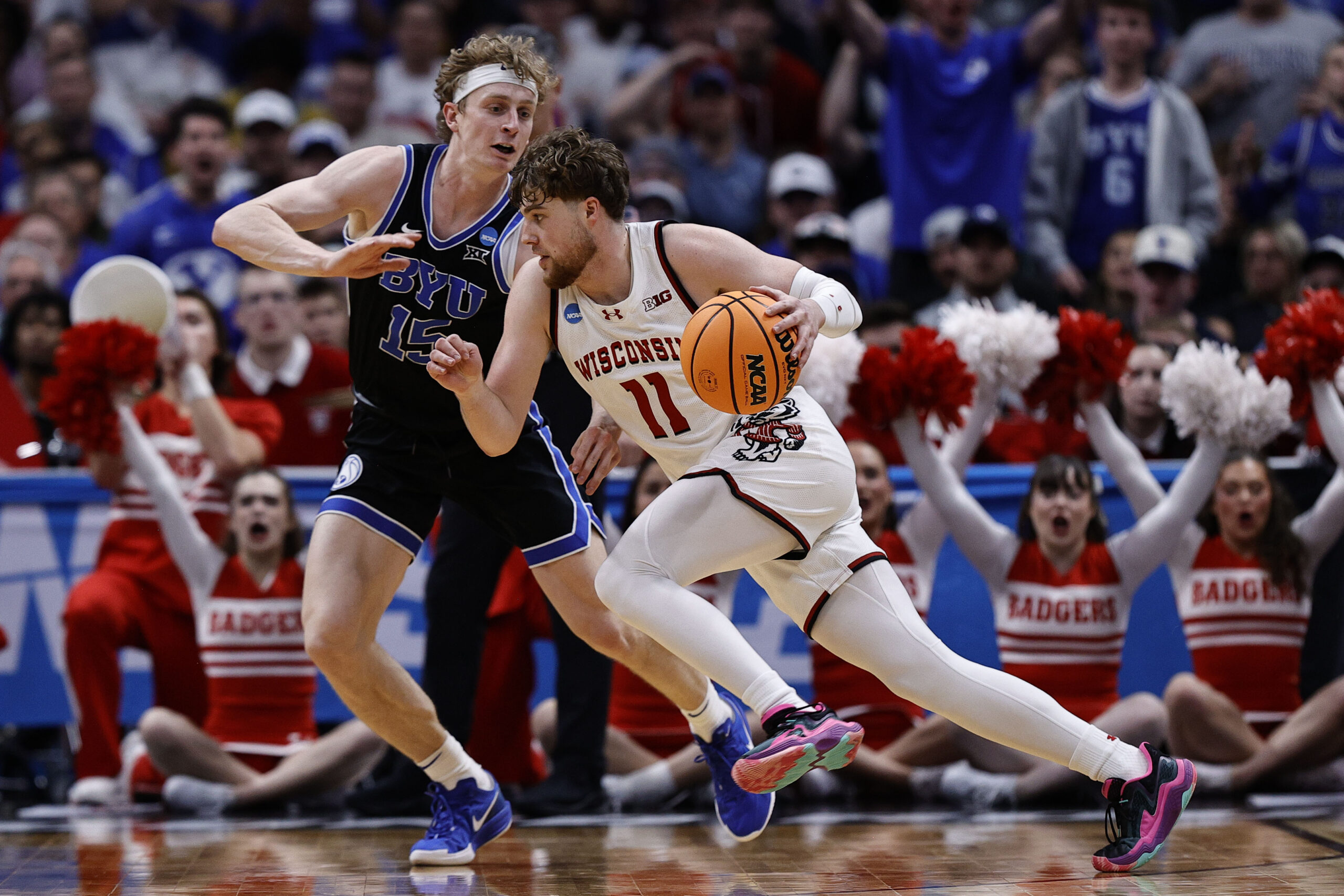 Mar 22, 2025; Denver, CO, USA; Wisconsin Badgers guard Max Klesmit (11) dribbles the ball past Brigham Young Cougars forward Richie Saunders (15) during the second half in the second round of the NCAA Tournament at Ball Arena. Mandatory Credit: Isaiah J. Downing-Imagn Images