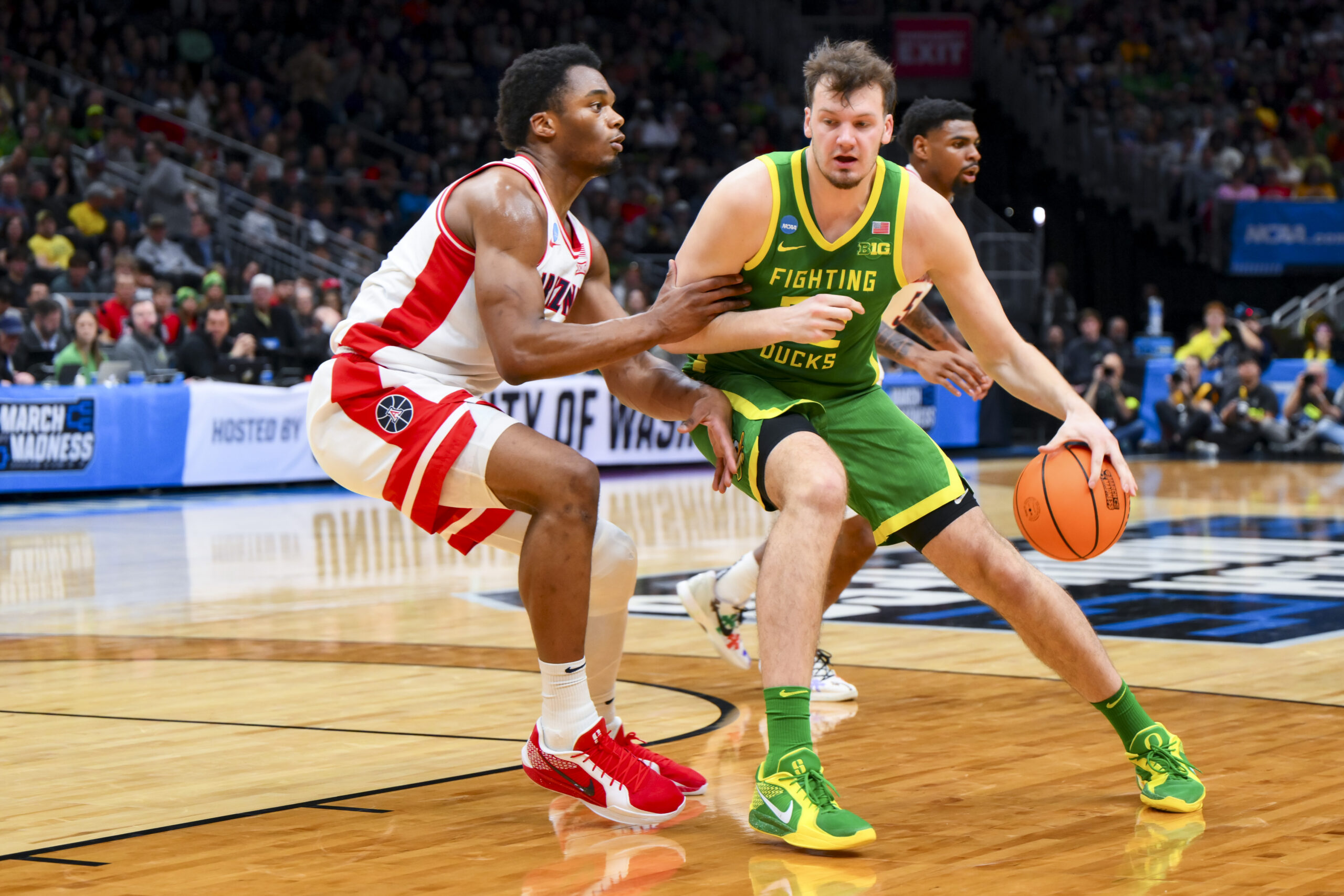 Mar 23, 2025; Seattle, WA, USA;  Oregon Ducks center Nate Bittle (32) dribbles the ball against Arizona Wildcats forward Tobe Awaka (30) in the first half at Climate Pledge Arena. Mandatory Credit: Steven Bisig-Imagn Images