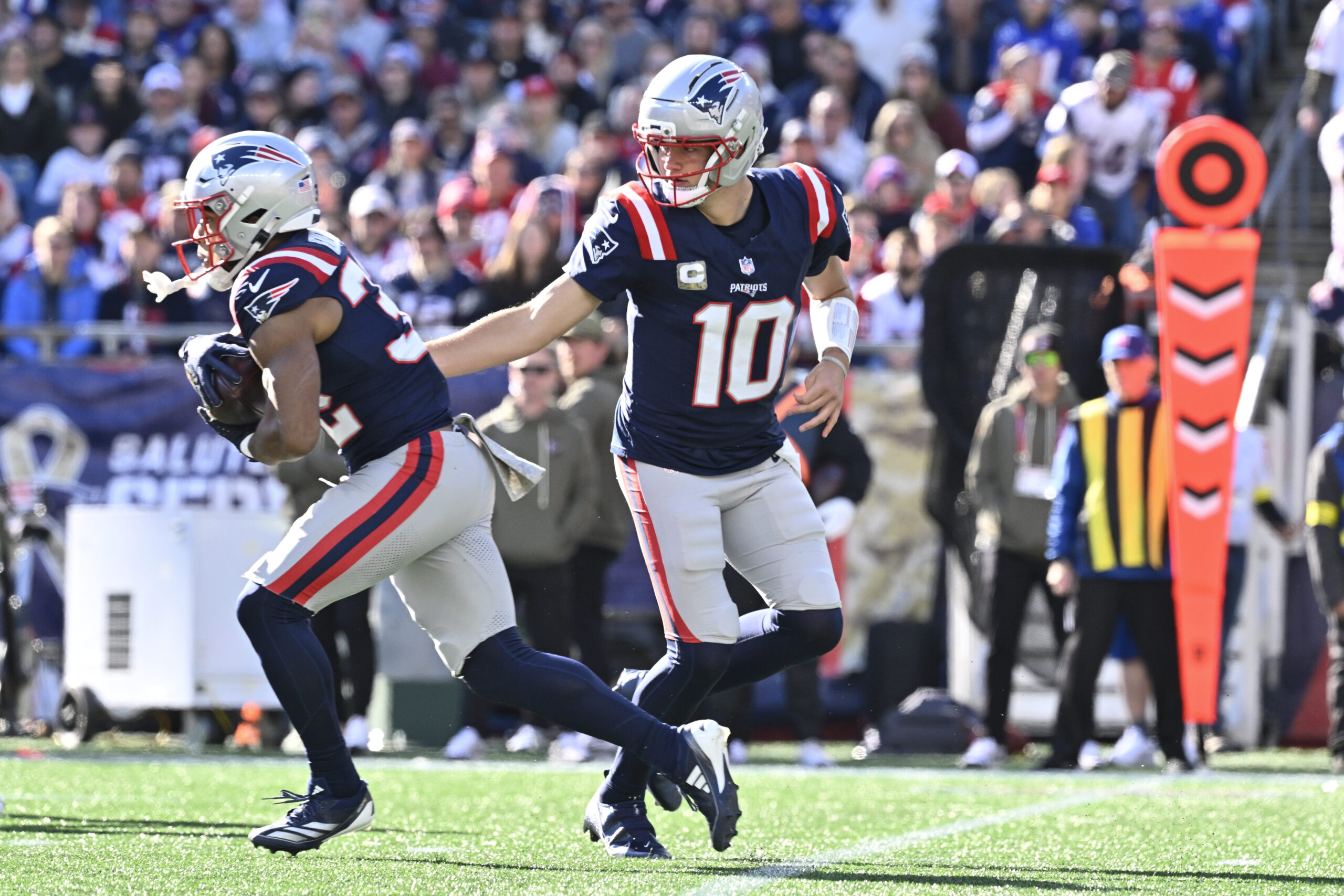 Nov 2, 2025; Foxborough, Massachusetts, USA; New England Patriots quarterback Drake Maye (10) hands the ball off to running back TreVeyon Henderson (32) during the first quarter at Gillette Stadium. Mandatory Credit: Eric Canha-Imagn Images